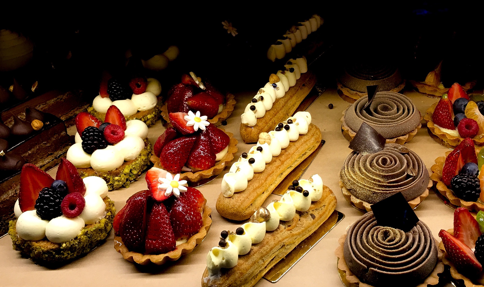 A bright colourful display of cakes in a shop window