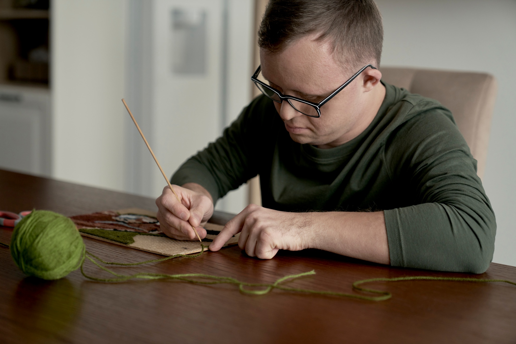 Adult caucasian man with down syndrome making a craft