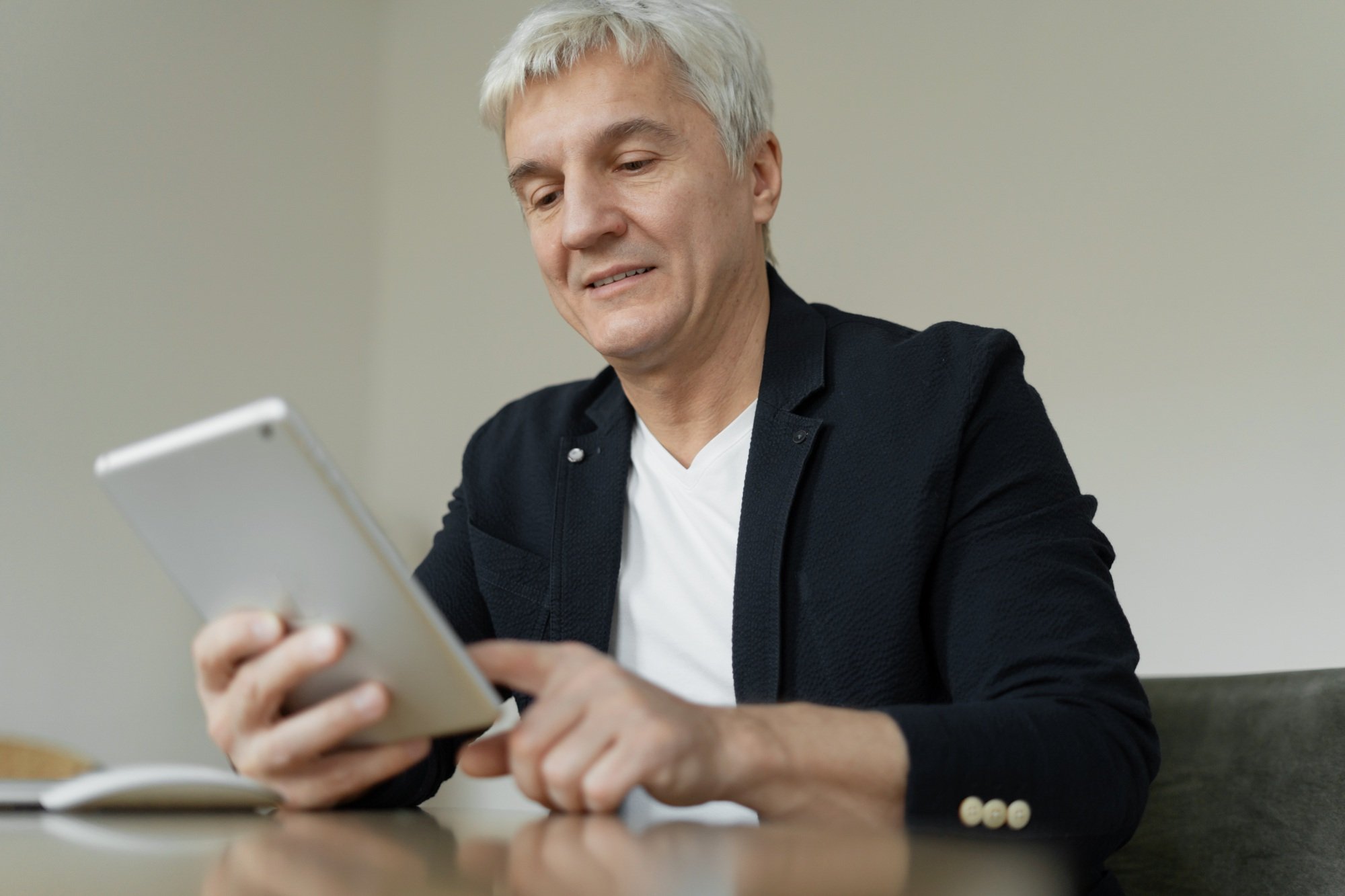 adult male businessman working on laptop in office workplace writes message to mail