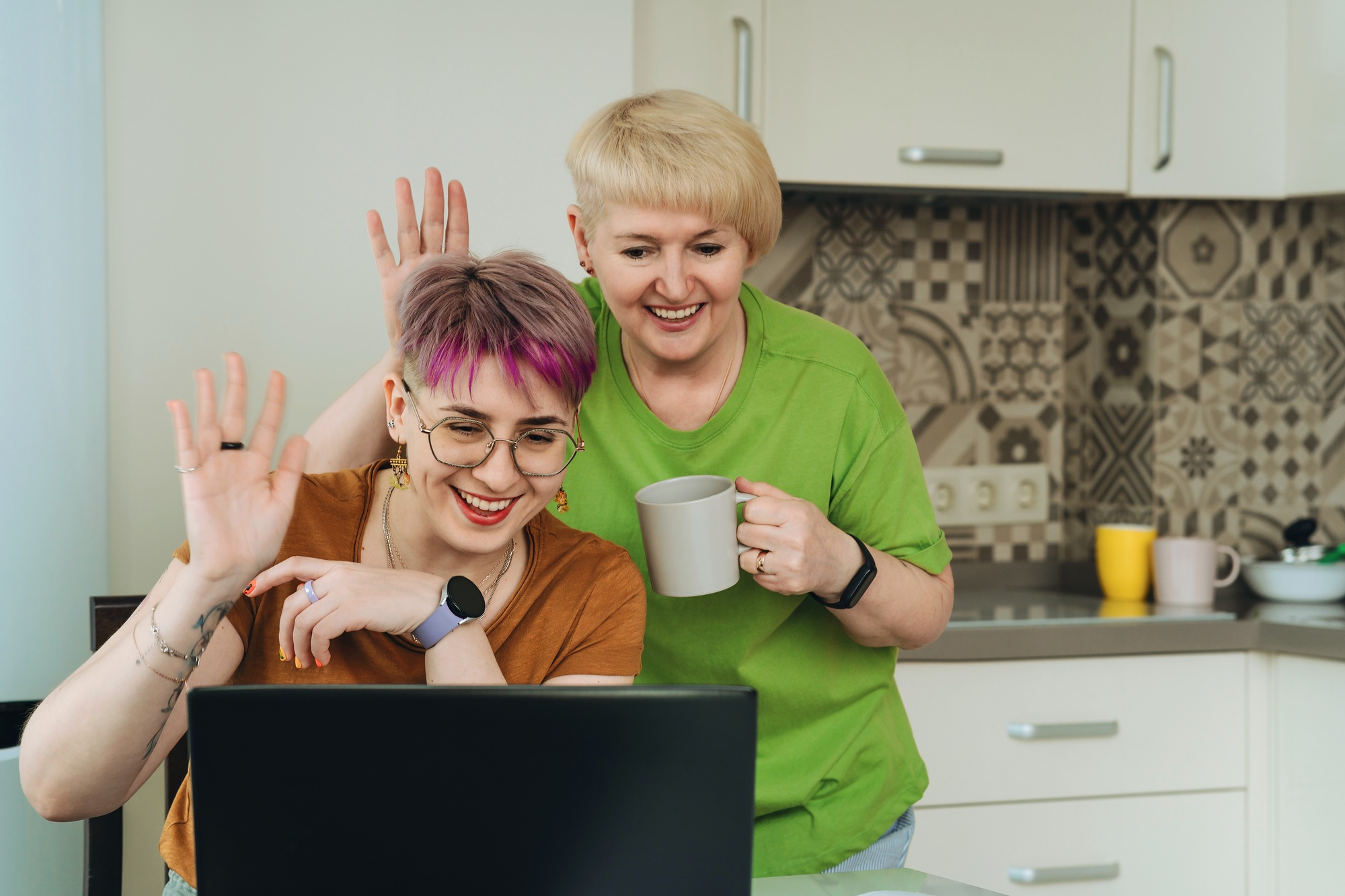 Adult mother and daughter communicate online via video chat on a laptop together