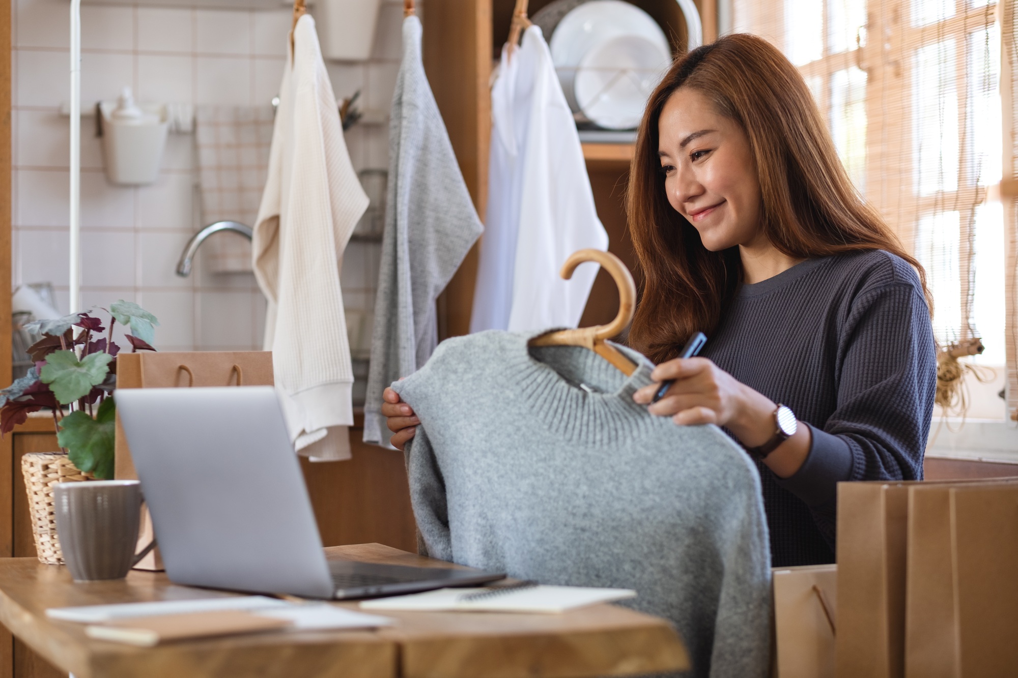 An entrepreneur using laptop computer for selling clothes online or review product on social media