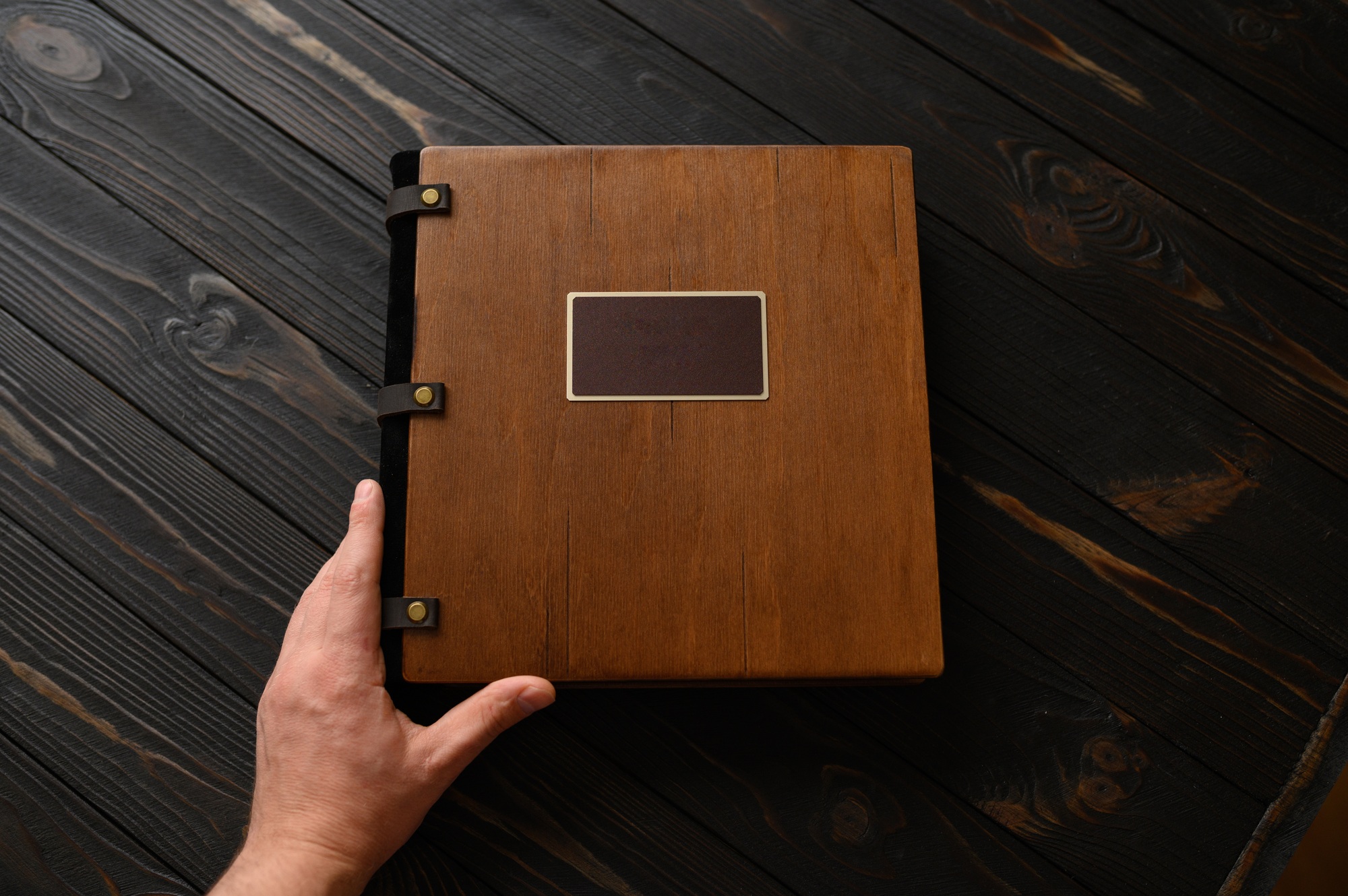 An old photo album with a wooden cover and a shield on a rustic table. free logo