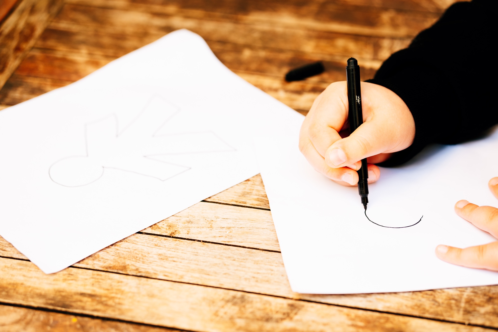 April Fool's Day concept. Child drawing papers with April Fool's Day dolls.