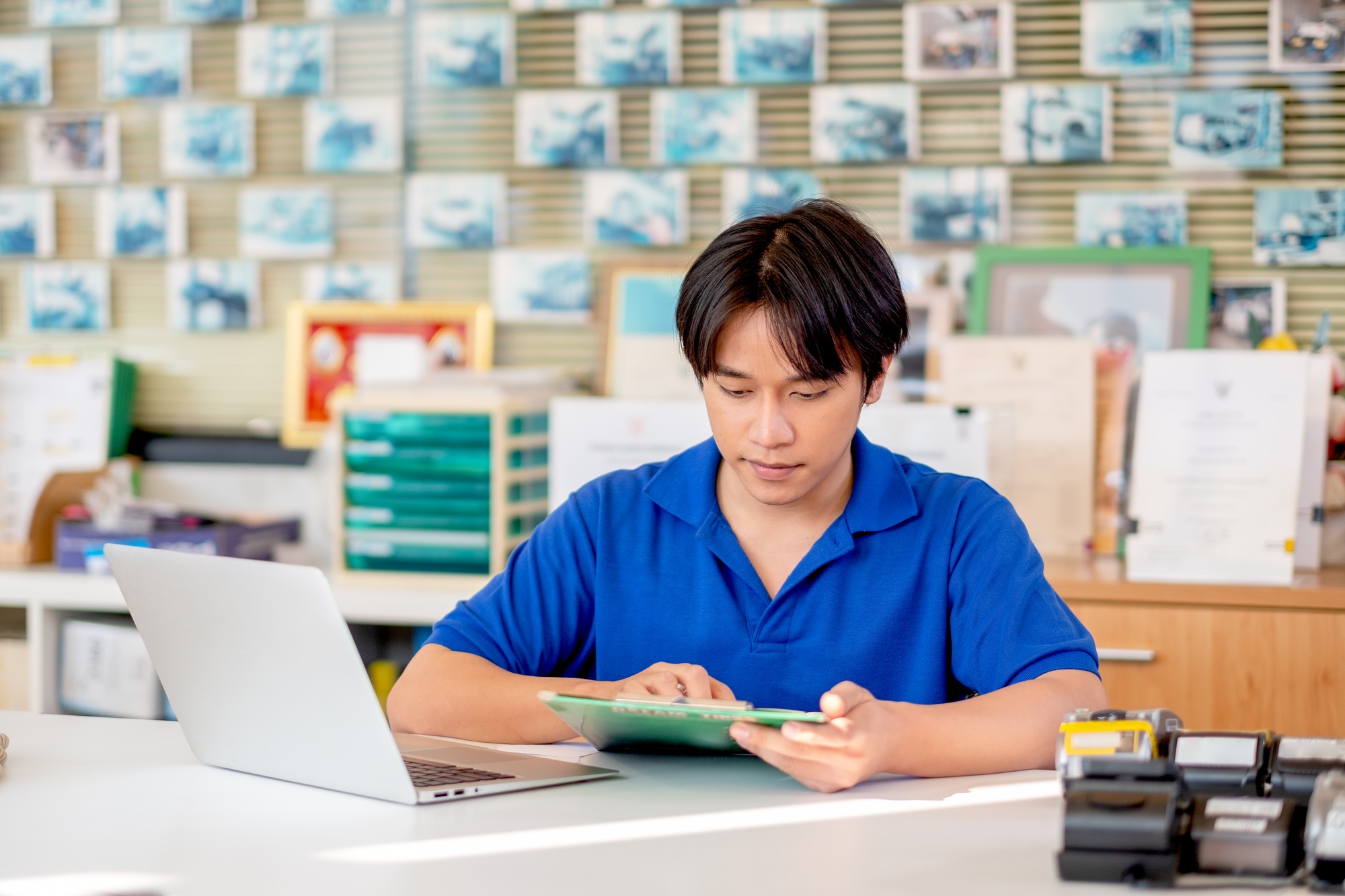 Automotive or garage worker with blue shirt uniform check list of document