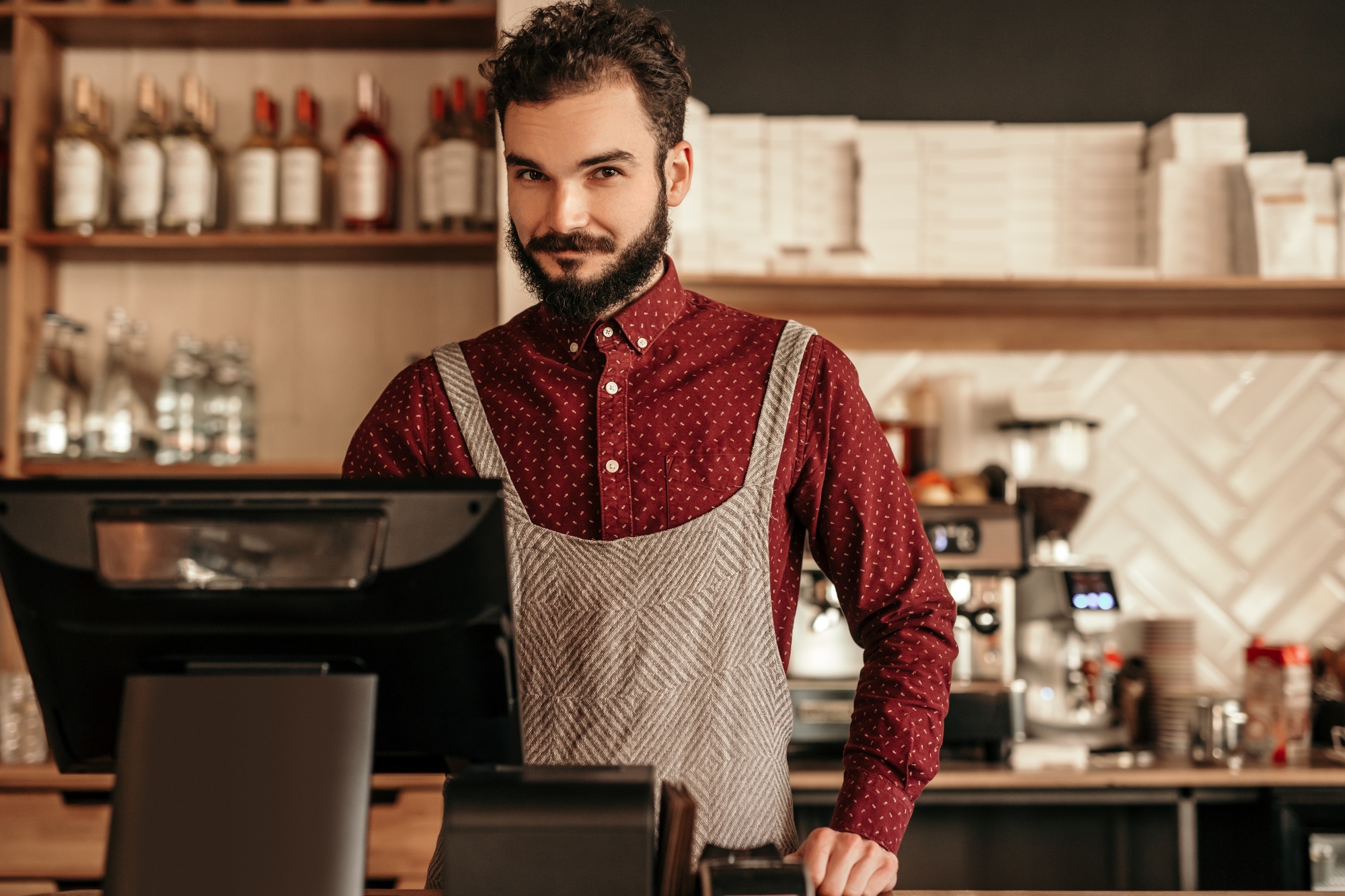 Bearded cashier working in cafe