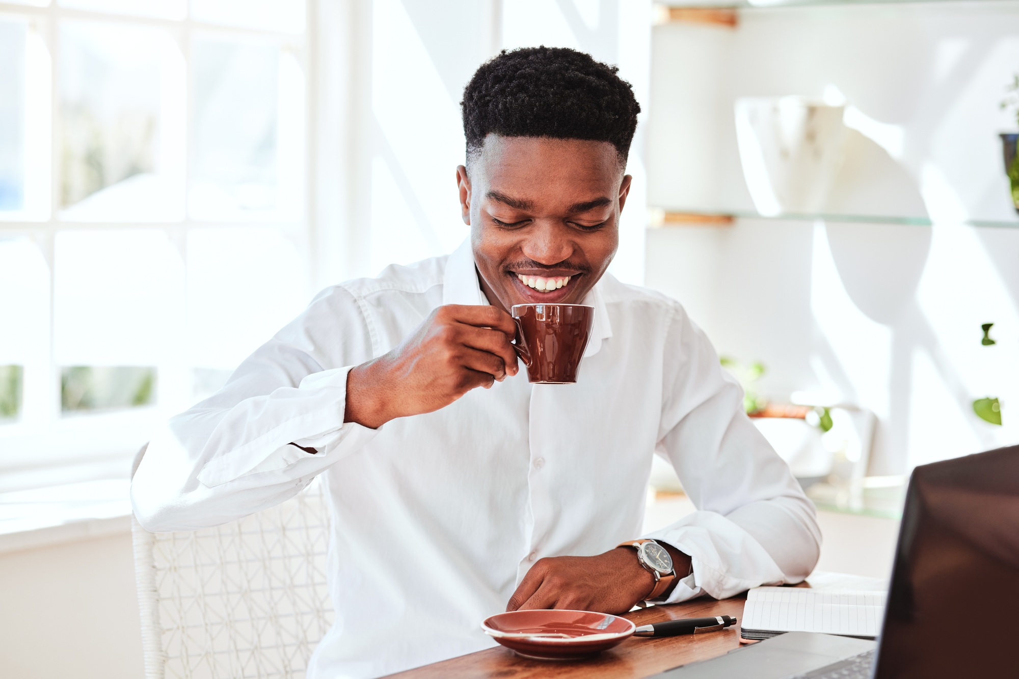 Black business man with tea, cafe restaurant for online work and happy startup manager in Chicago.
