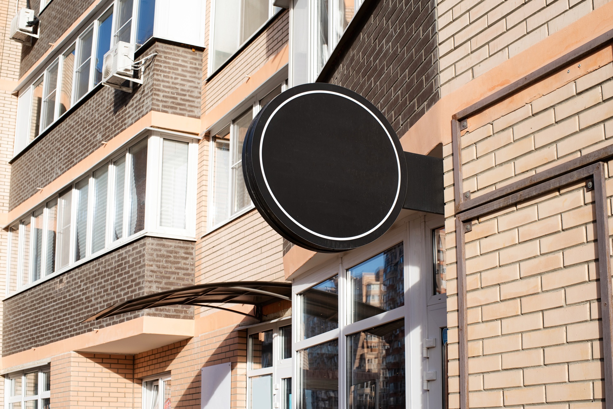 Black round logo on brick wall building exterior for mockup design