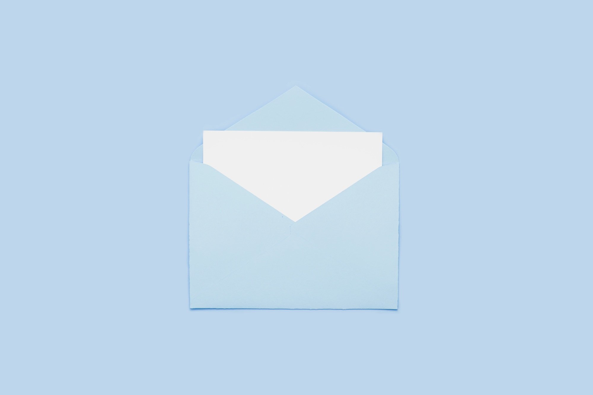 Blank empty white paper card in blue opened envelope isolated on blue background