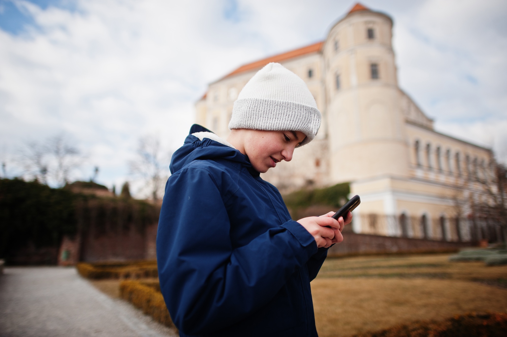 Boy looking at phone in historical Mikulov Castle, Moravia, Czech Republic. Old European town.