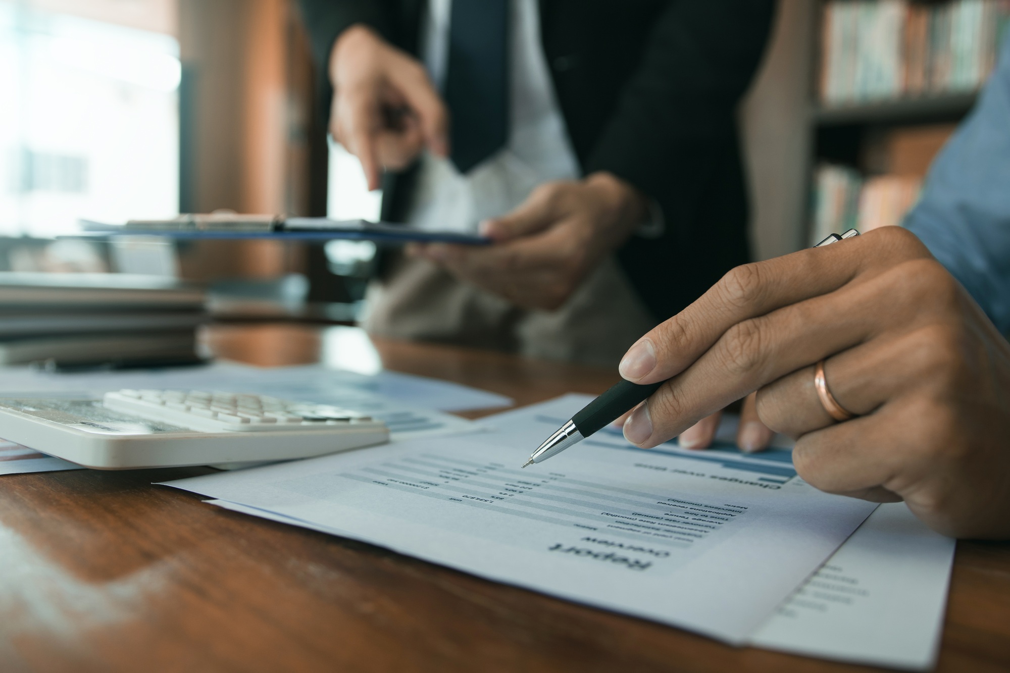 Business partnership pointing to the graph of the company financial statements report and profits ea