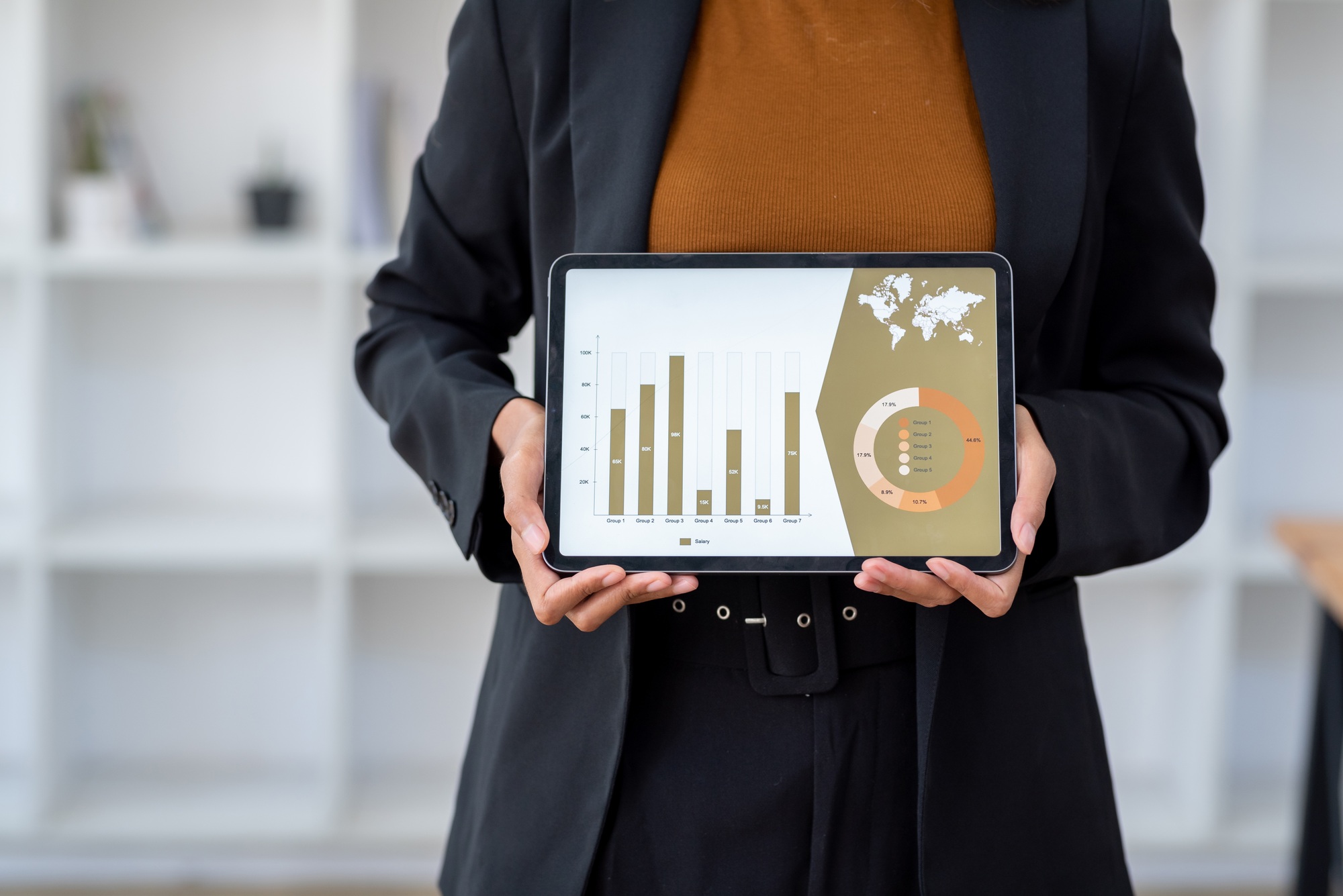 Business professional holding tablet displaying analytics chart.