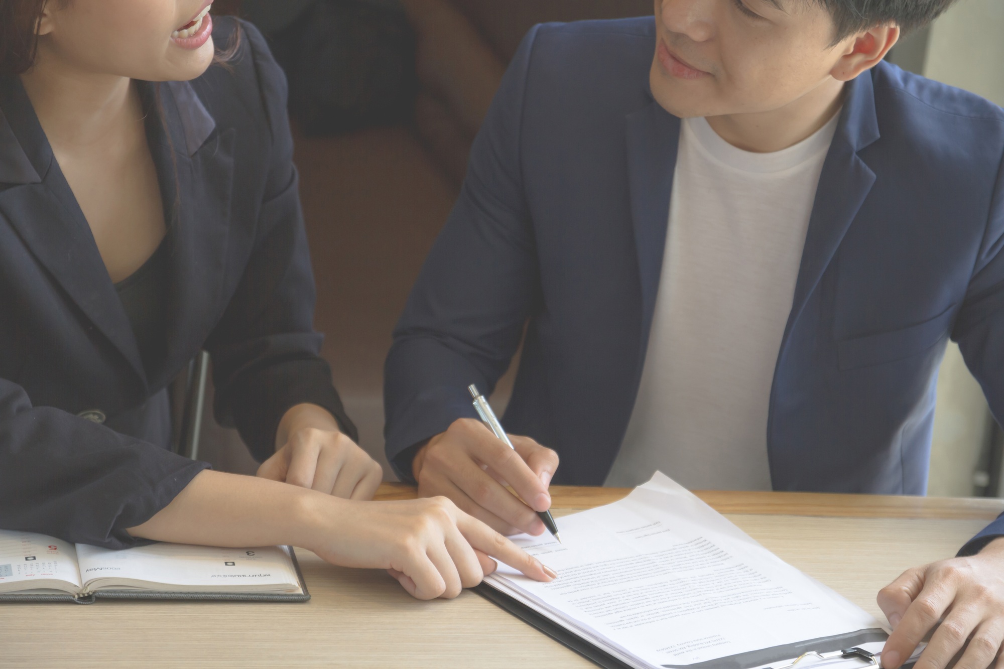 Businessman and businesswoman signing paper (insurance, contract, important)