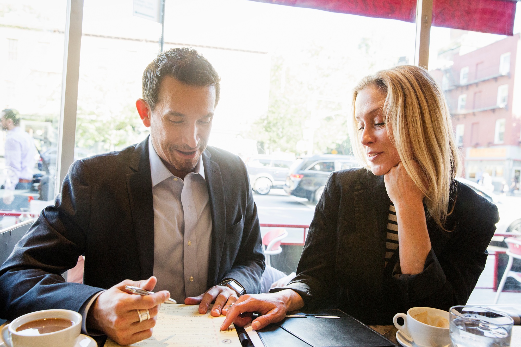 Businesswoman and businessman sitting at a table in a cafe, a working lunch, a meeting.