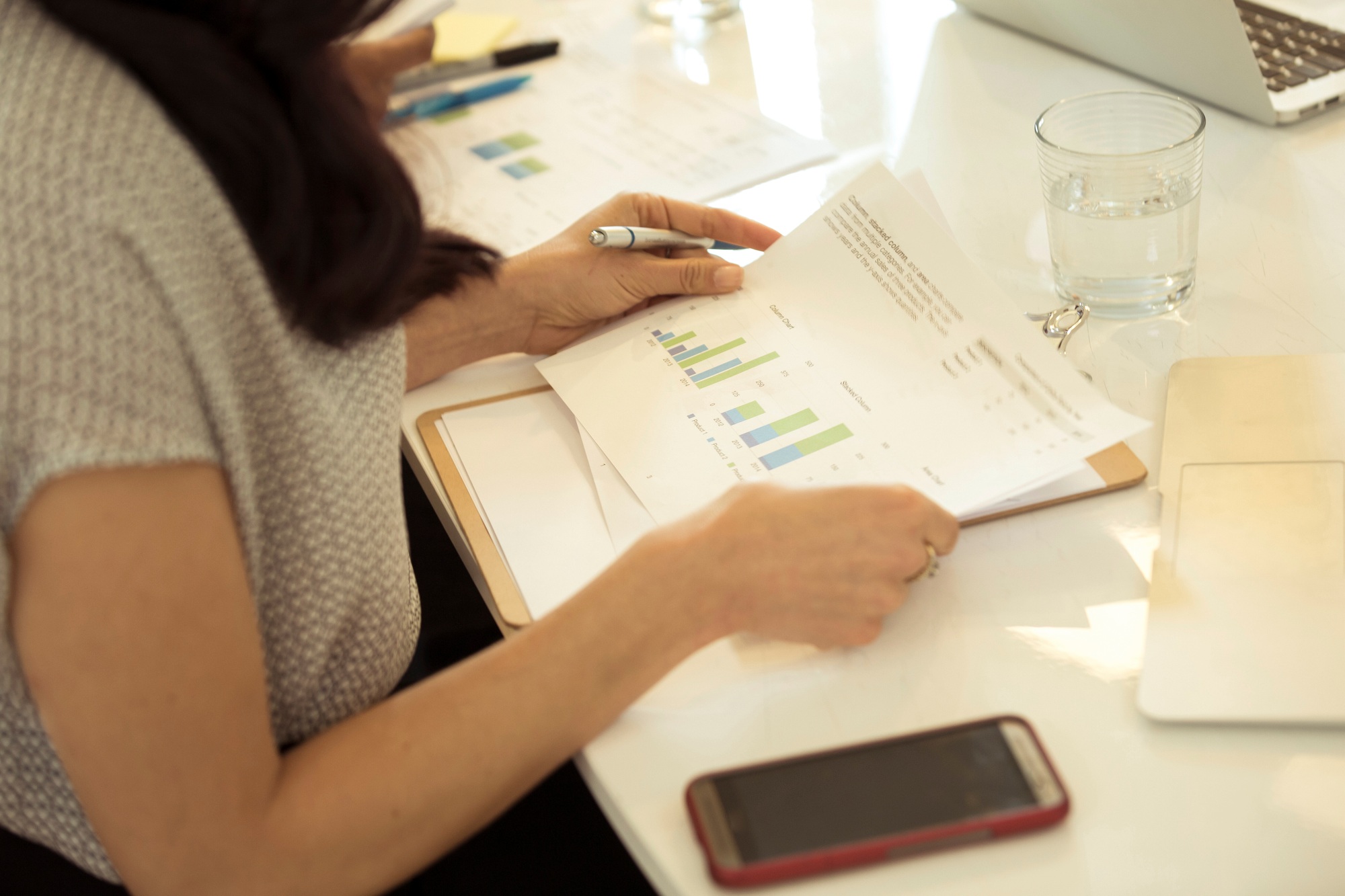 Businesswoman looking at bar charts at desk