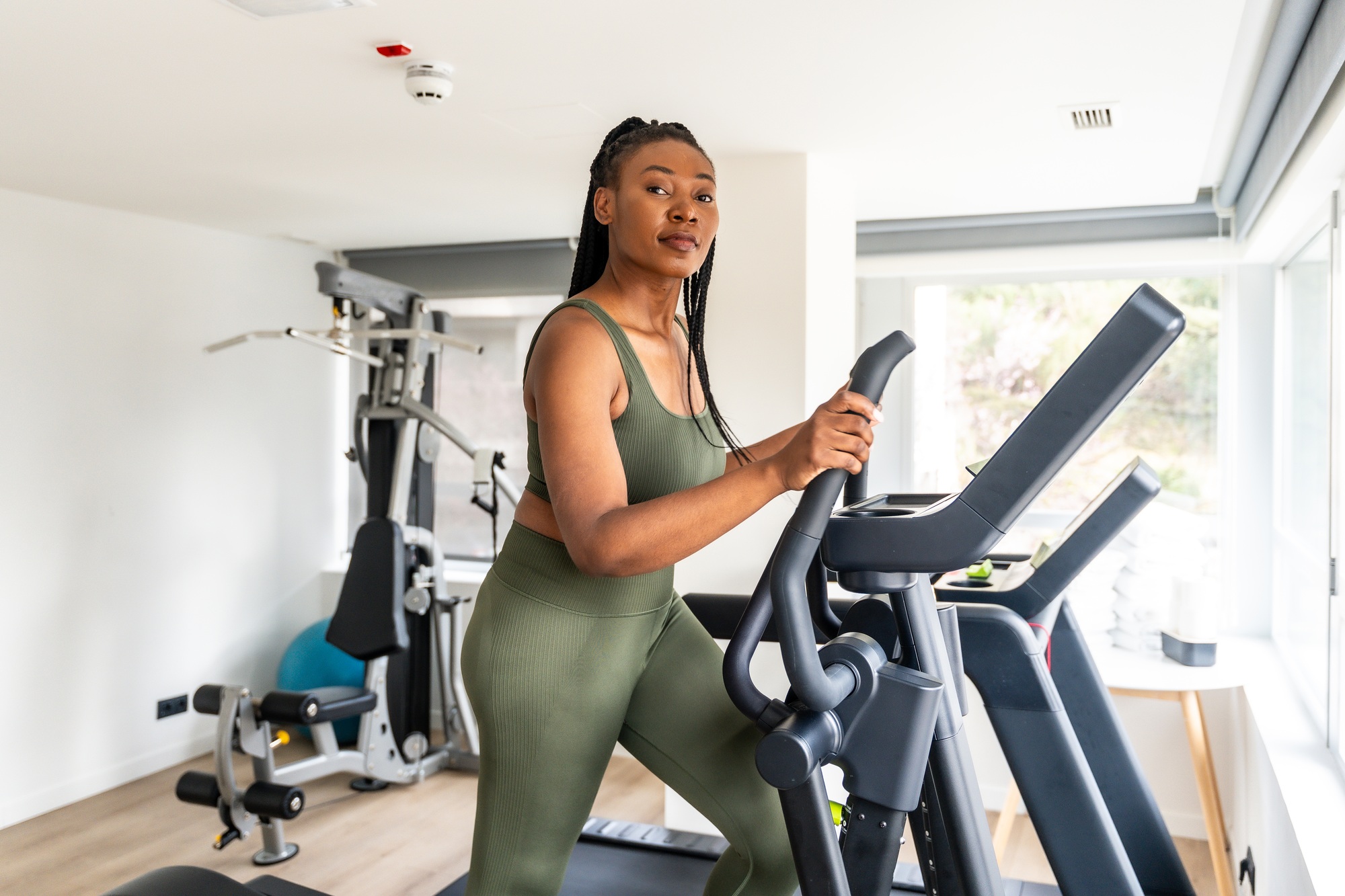 Businesswoman working out on elliptical machine in hotel gym