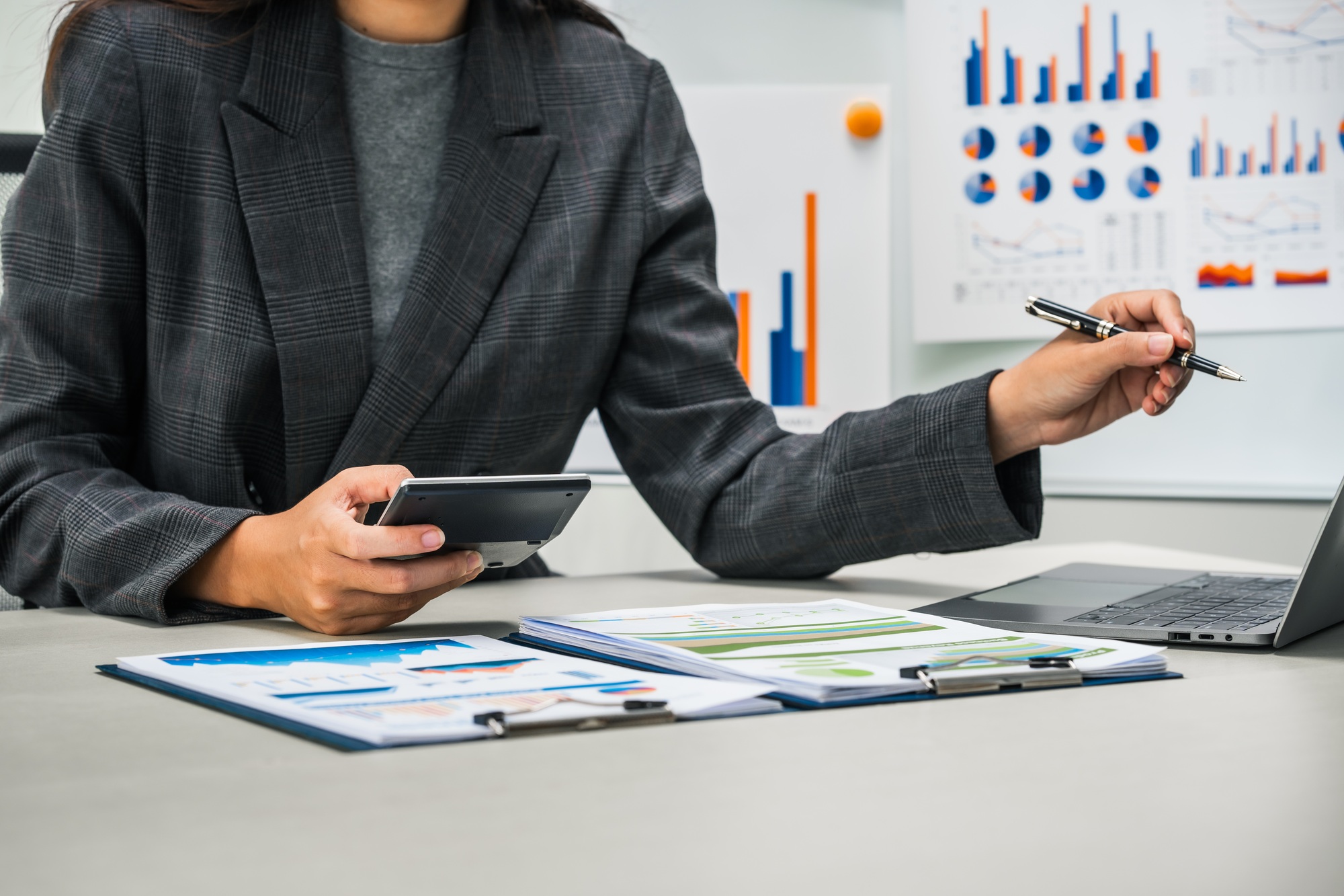 businesswoman works diligently at her desk, reviewing financial documents and analyzing investment