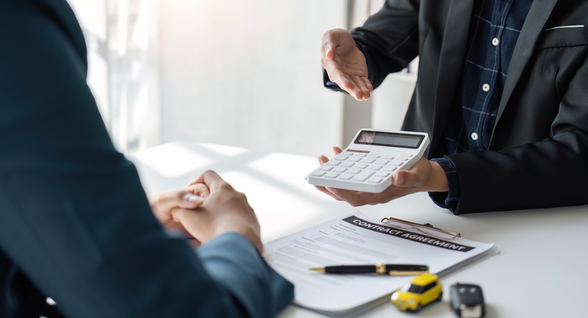 Car Insurance document or lease concept the car broker assisting his customer and explaining the