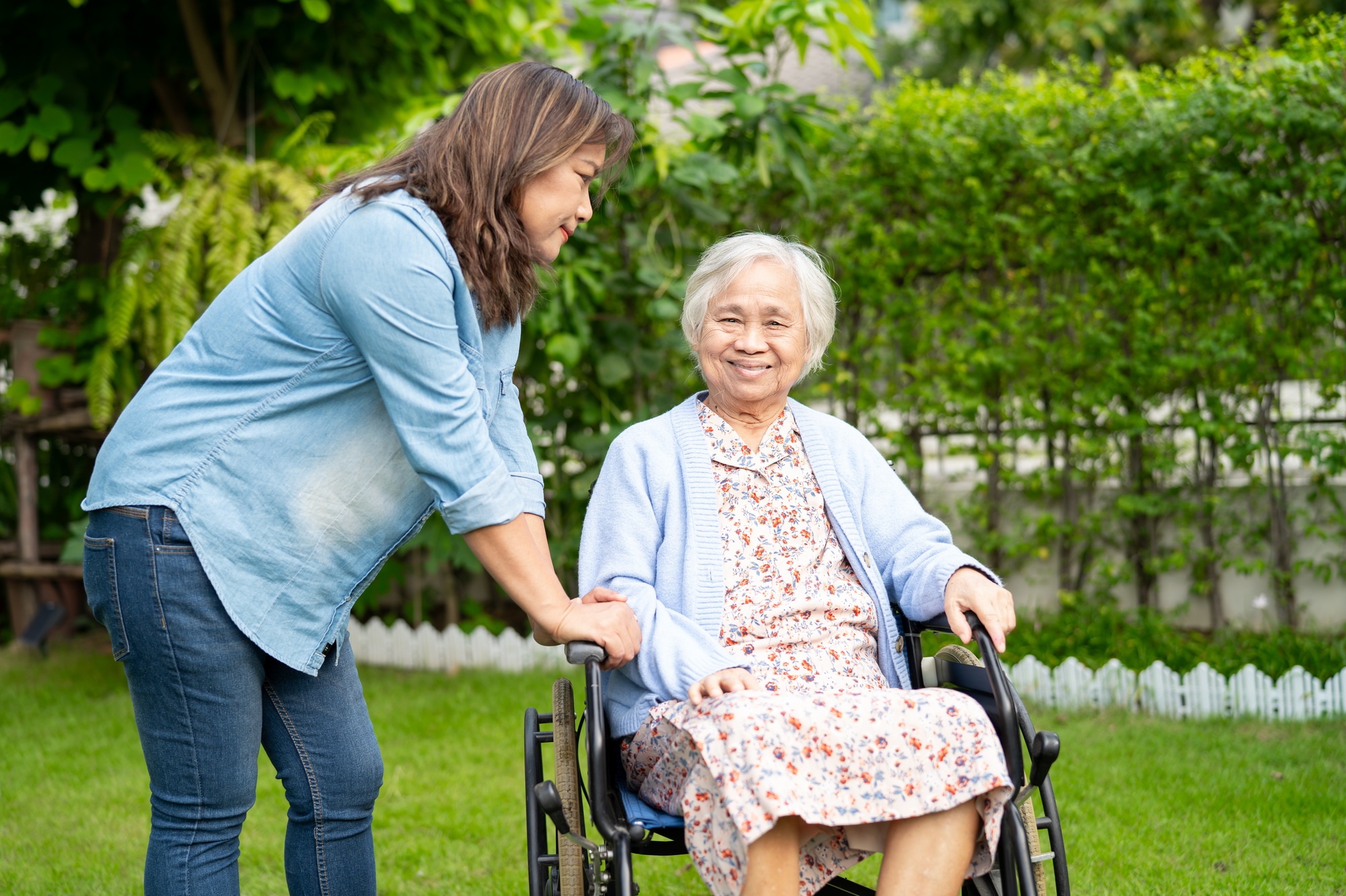 Caregiver help and care Asian senior woman patient sitting on wheelchair
