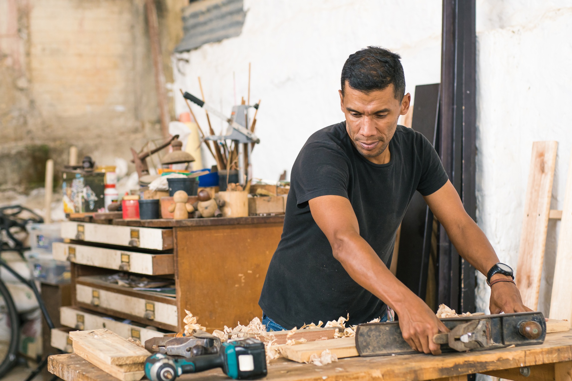 Carpenter: Latin American worker in his workshop using different tools.