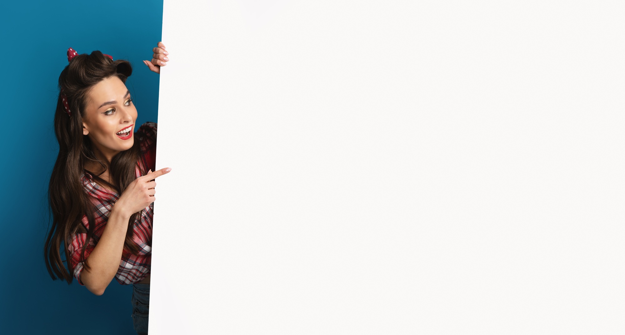 Cheerful pinup woman peeking from behind blank white poster, showing mockup for logo, design or