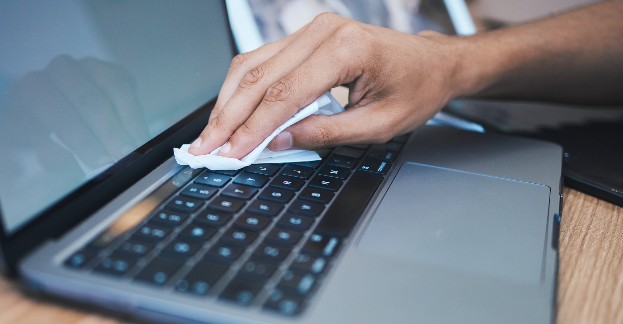 Cleaning, wipe dust and hands with laptop for hygiene, disinfection and maintenance for health in o