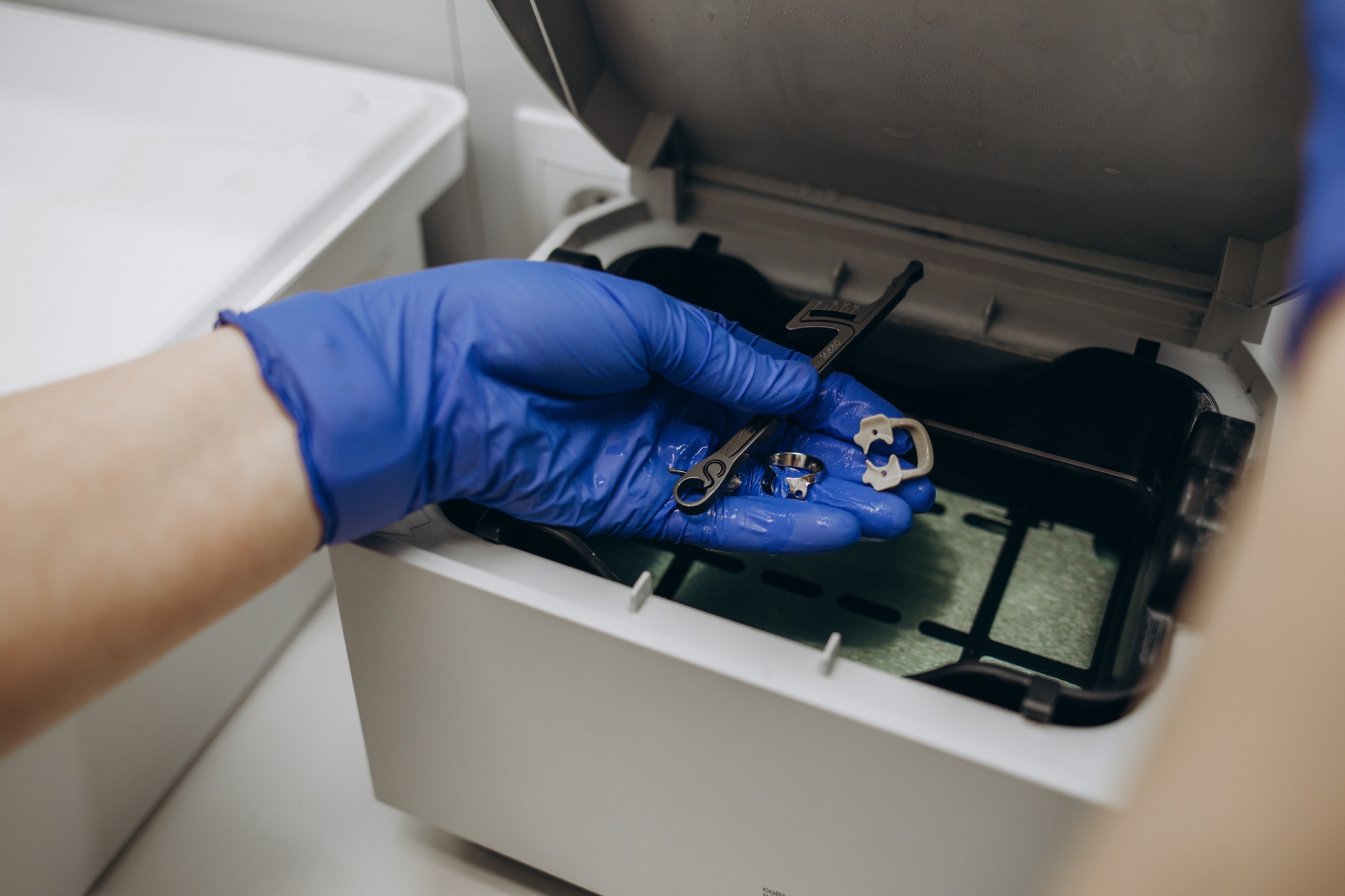 Close-up hands with gloves in the places medical autoclave for sterilising surgical