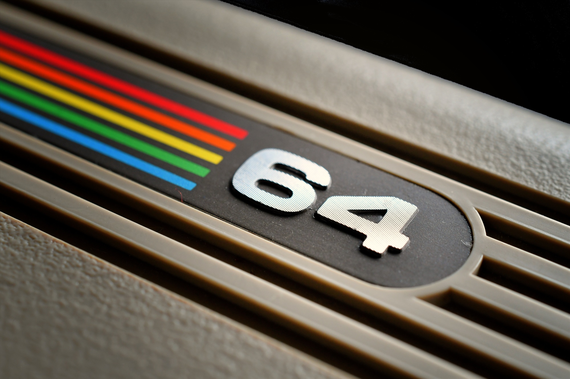 Close up of the Commodore 64 rainbow logo badge on a vintage computer keyboard
