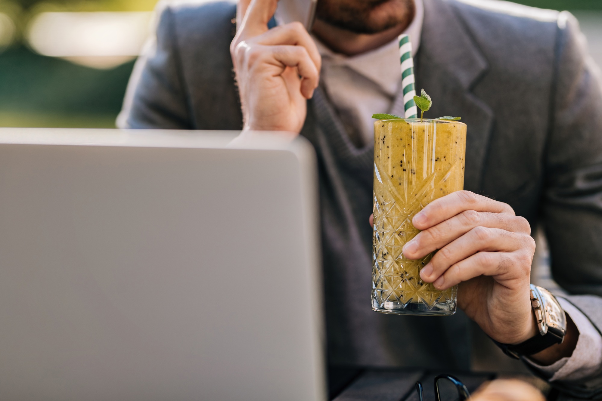 Close-up of unrecognizable businessman drinking smoothie.