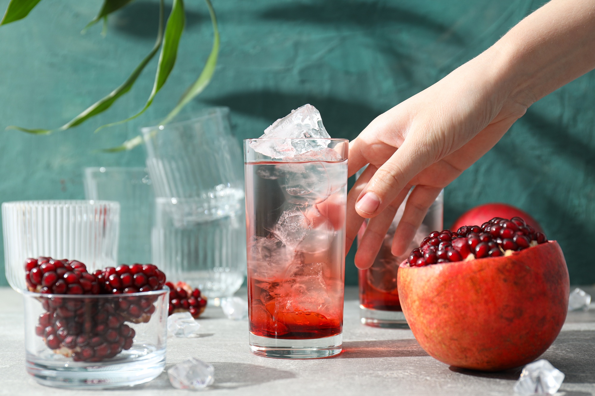 Cocktail with pomegranate juice and ice cubes on the table