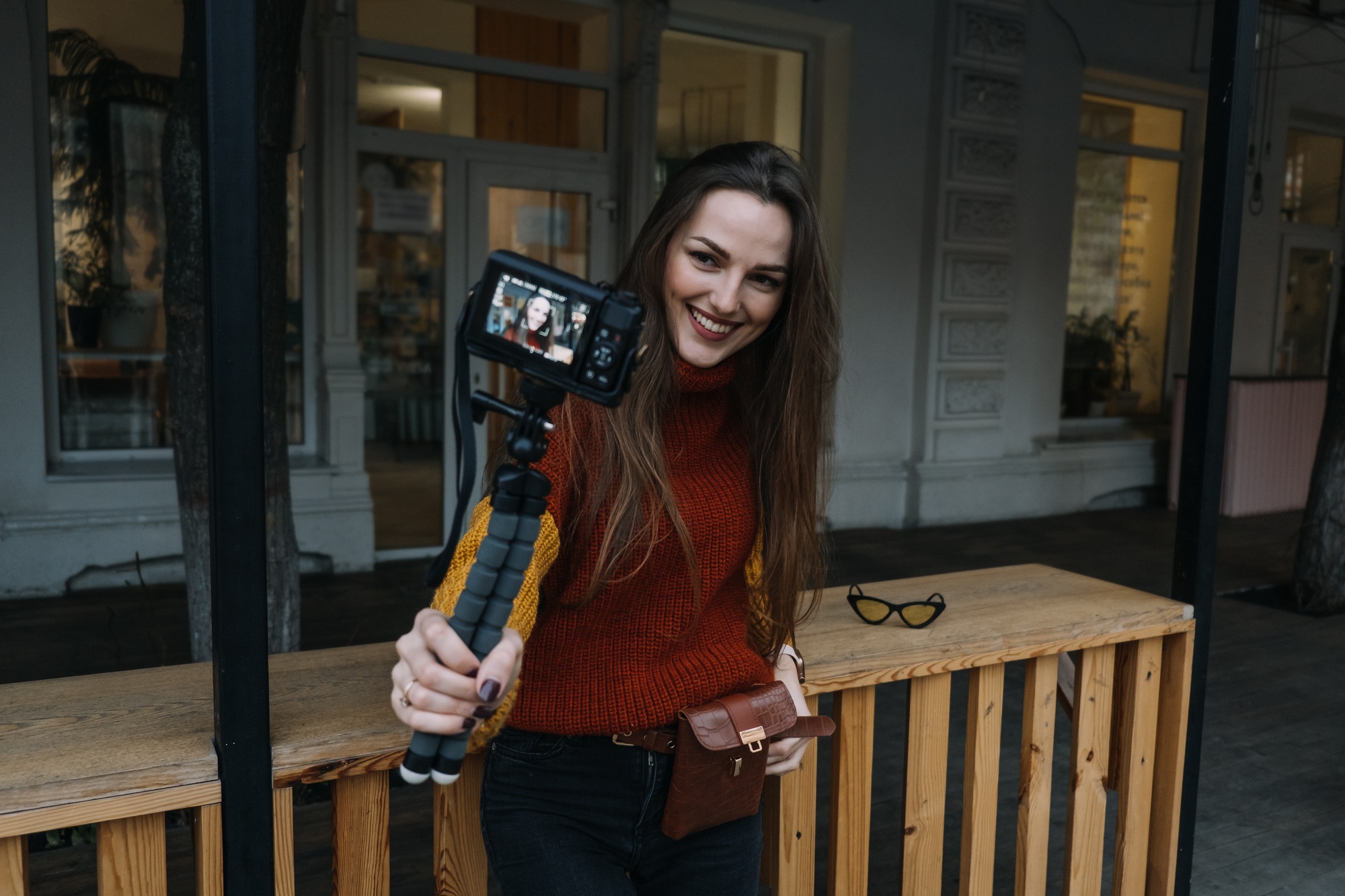 Content creator, blogger, vlogger young woman taking selfies, filming herself and having fun on city