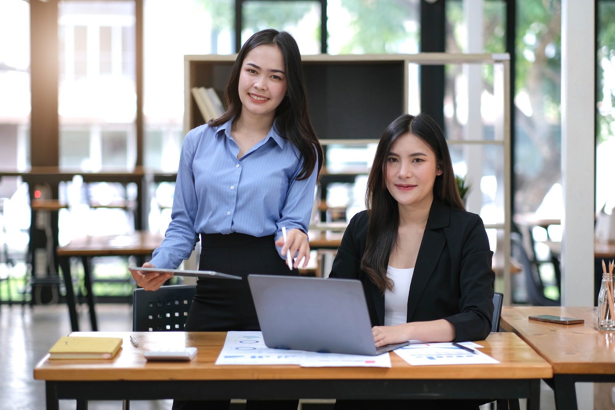 Creative young Asian business woman meeting to plan events. Take note of the job description