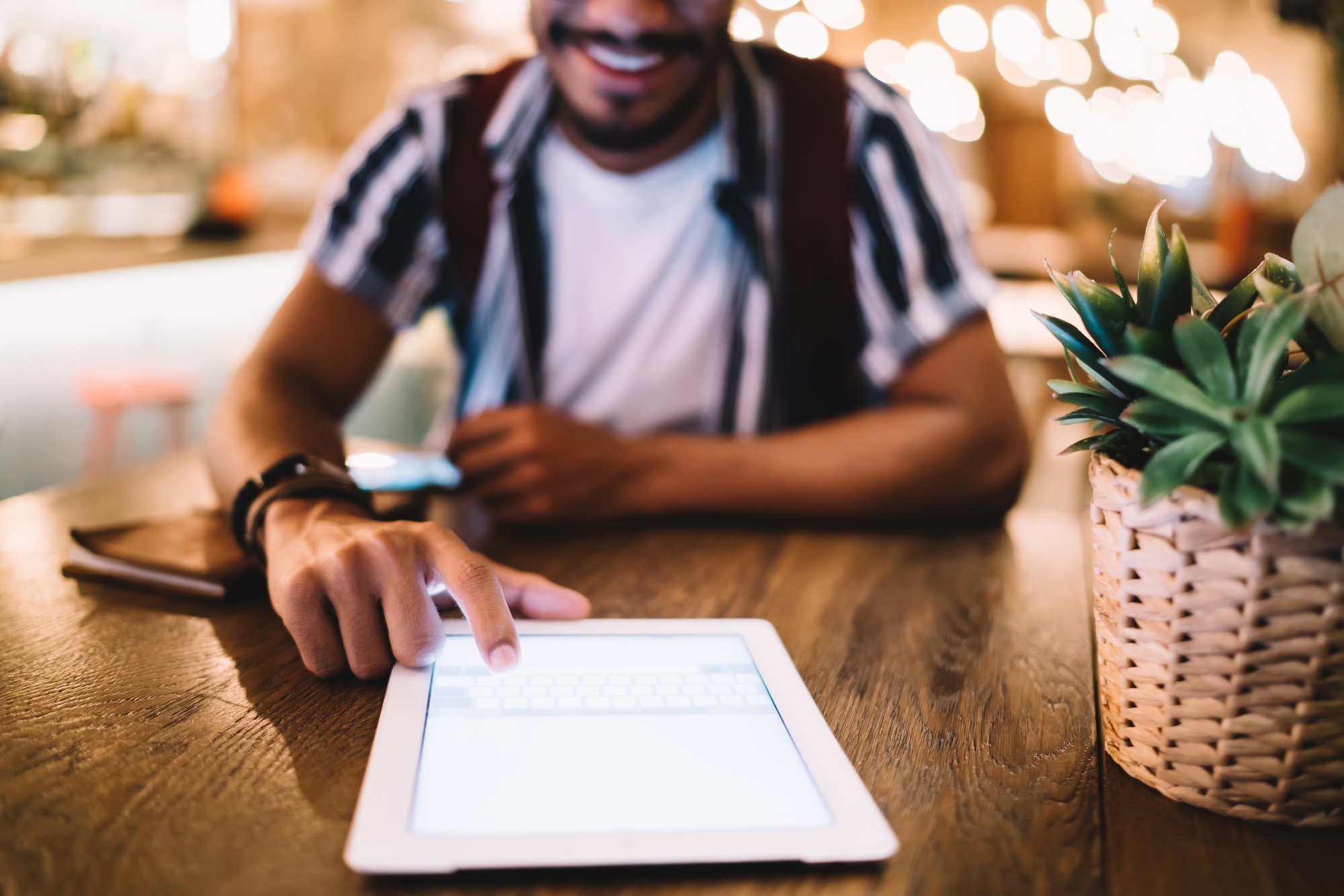 Cropped image of male typing message on modern digital tablet with mock up screen