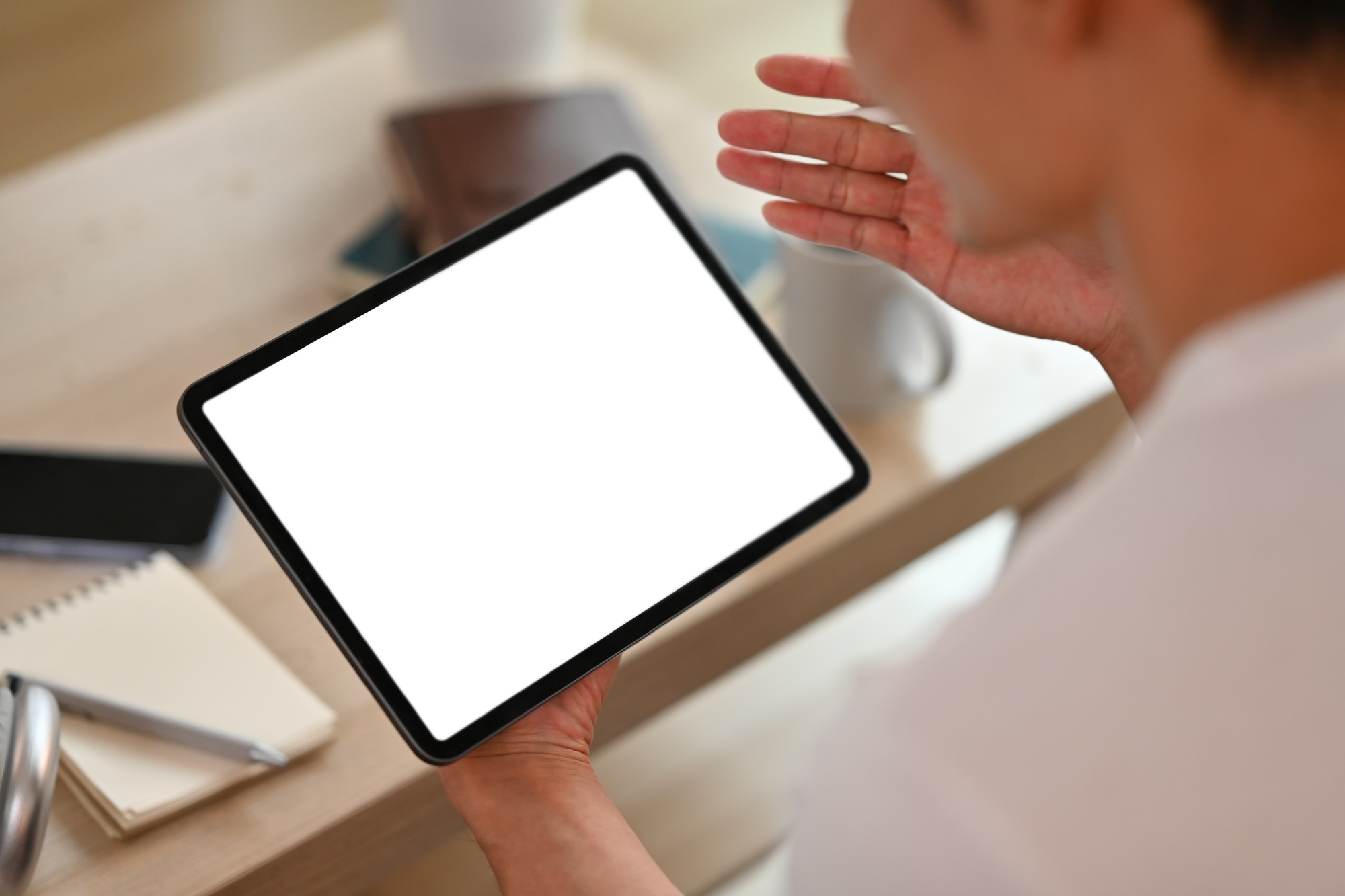 Cropped image of man using digital tablet in living room.