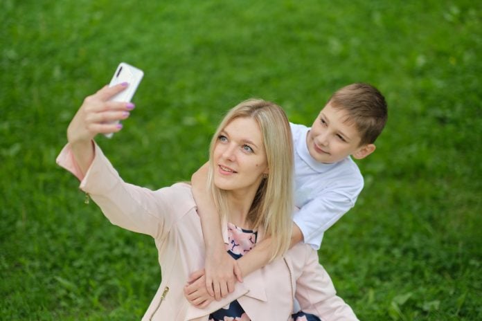 Digital memories: A mother and her teenage boy happily document their time together with a