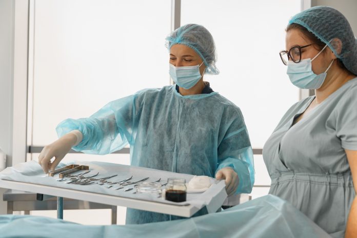 Doctor and nurse examining table with surgical instruments before the operation