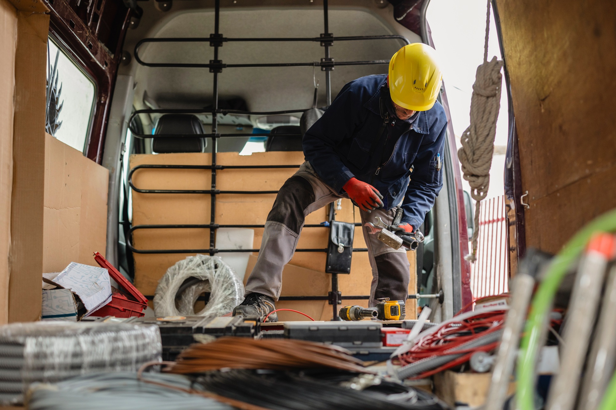 Electrician preparing cables and equipment in van for installation