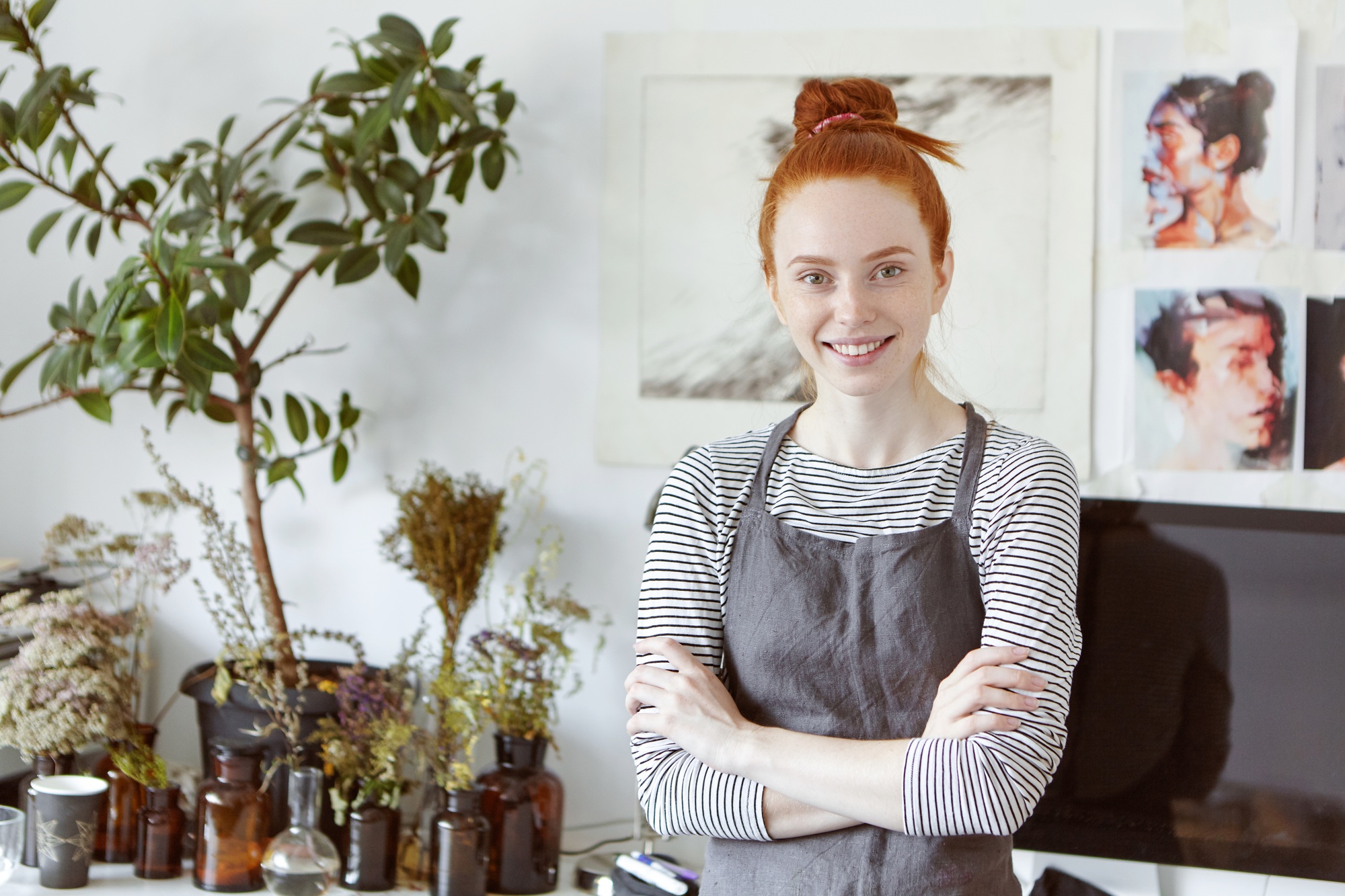 Enjoying process of creation. Attractive successful young ginger female artisan, artist or designer
