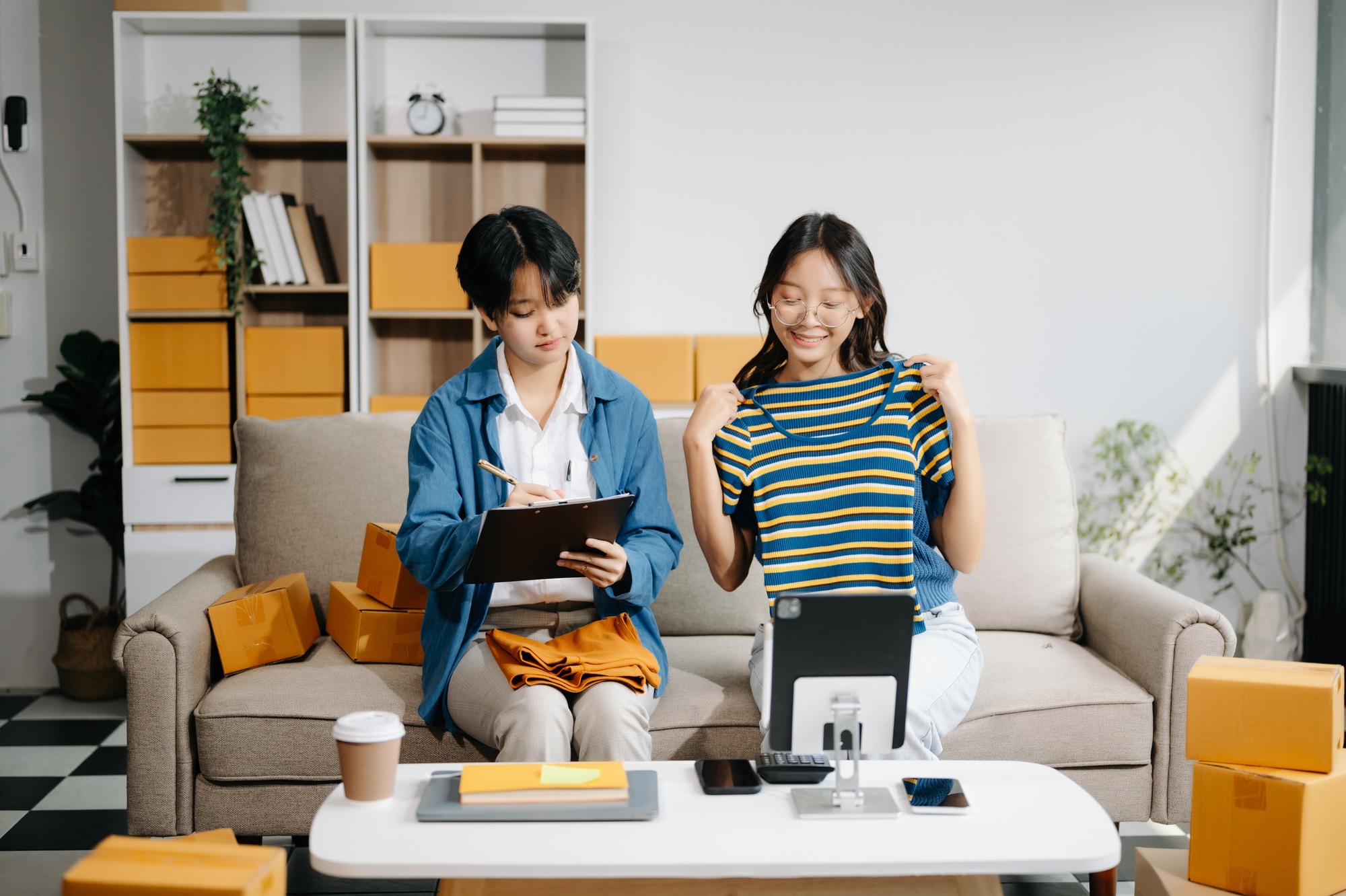 Fashion blogger concept, Two Asian women selling clothes on video streaming.Startup small business