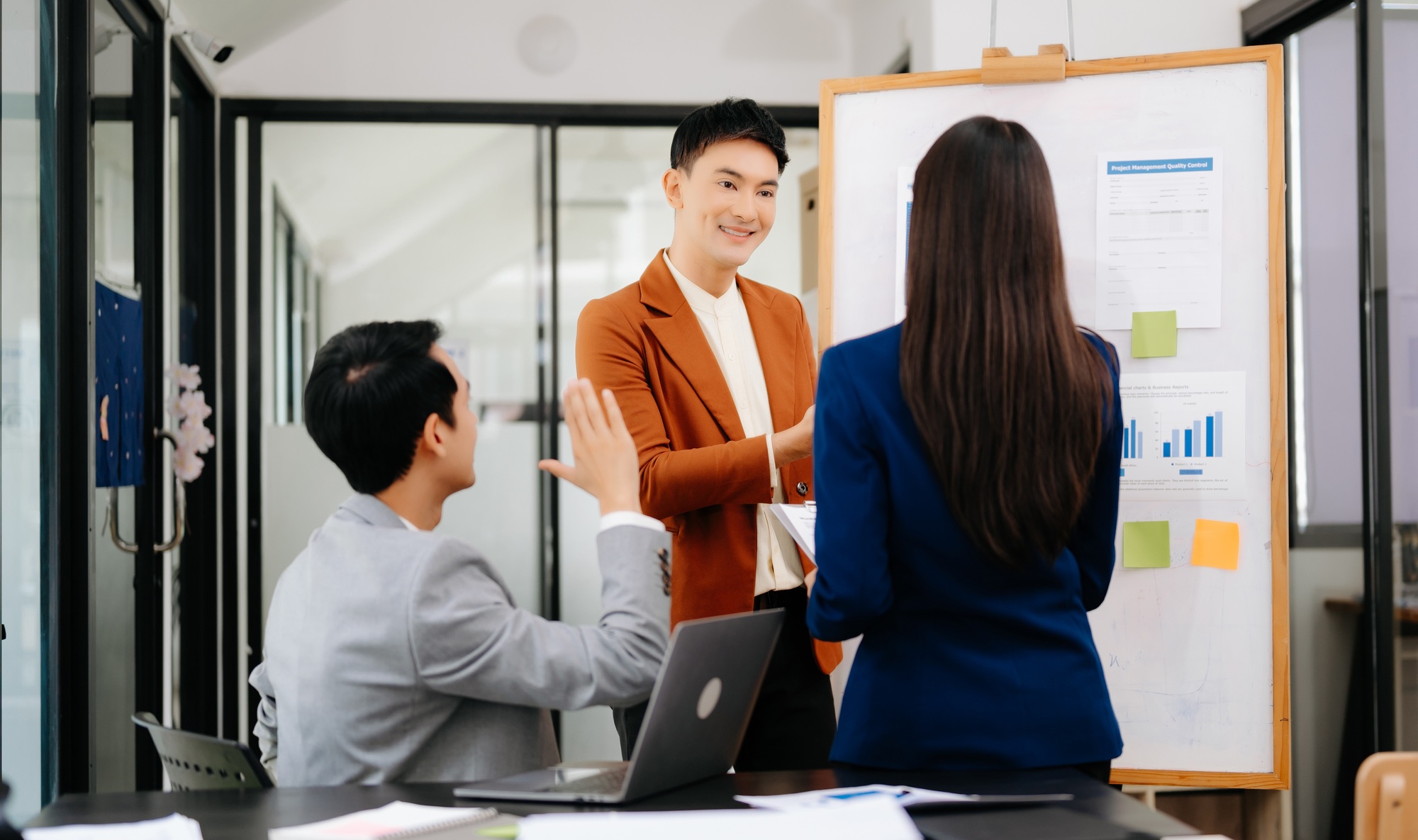 Group of young Asian business people discussing business plan at modern startup
