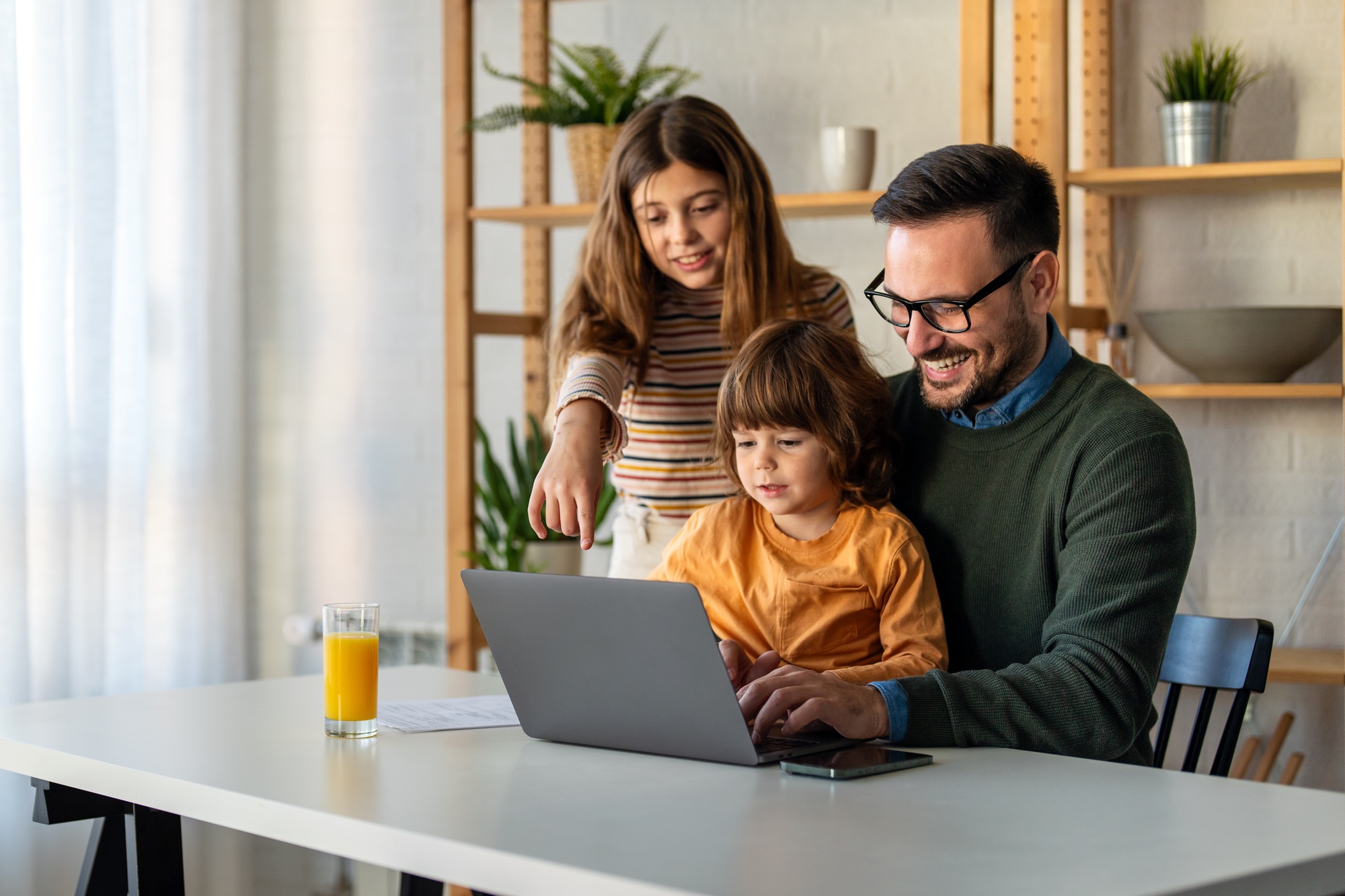 Happy single parent with cute excited small kid son using laptop computer at home. Technology