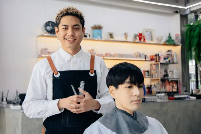 Happy young hairdresser in parlour