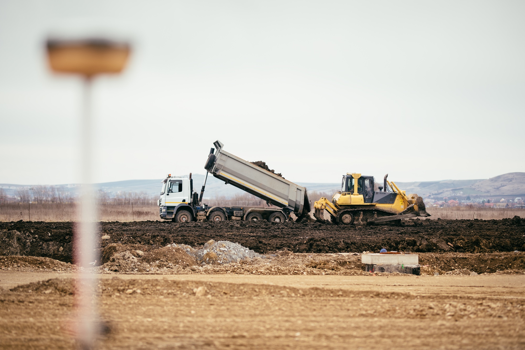 highway construction site development with dumper truck dumping earth