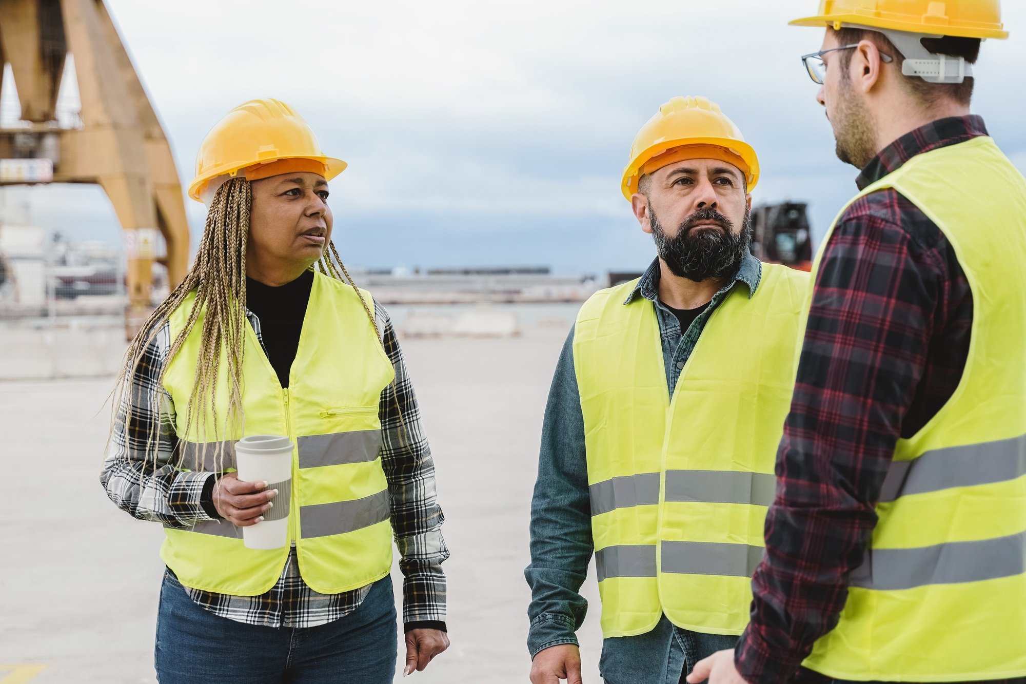 Industrial engineers working at container cargo logistics terminal - Diverse industry team concept