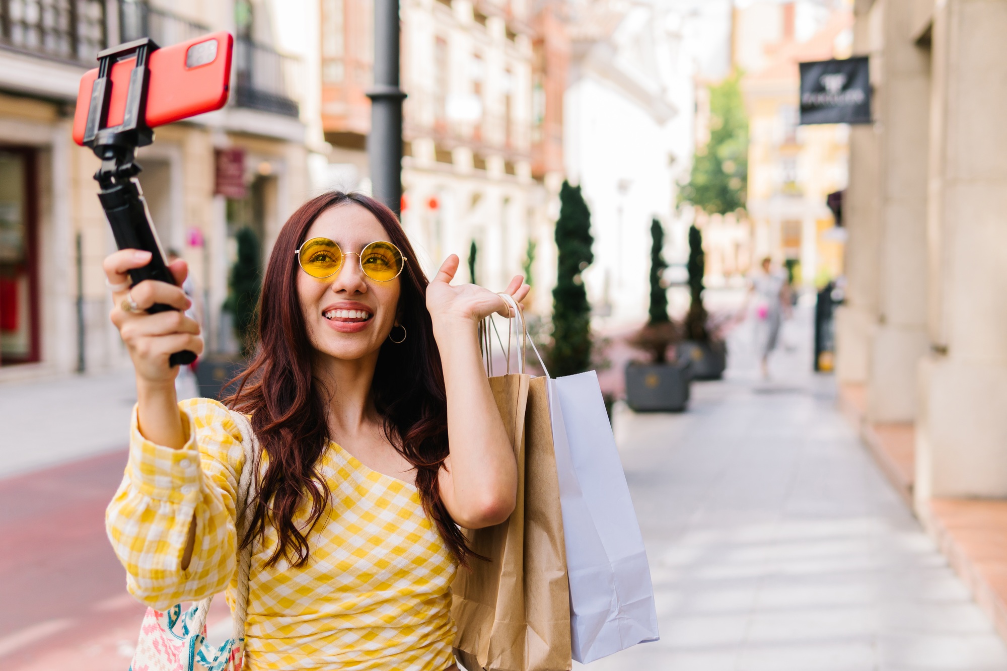 Influencer making shopping video holding bags and gimbal