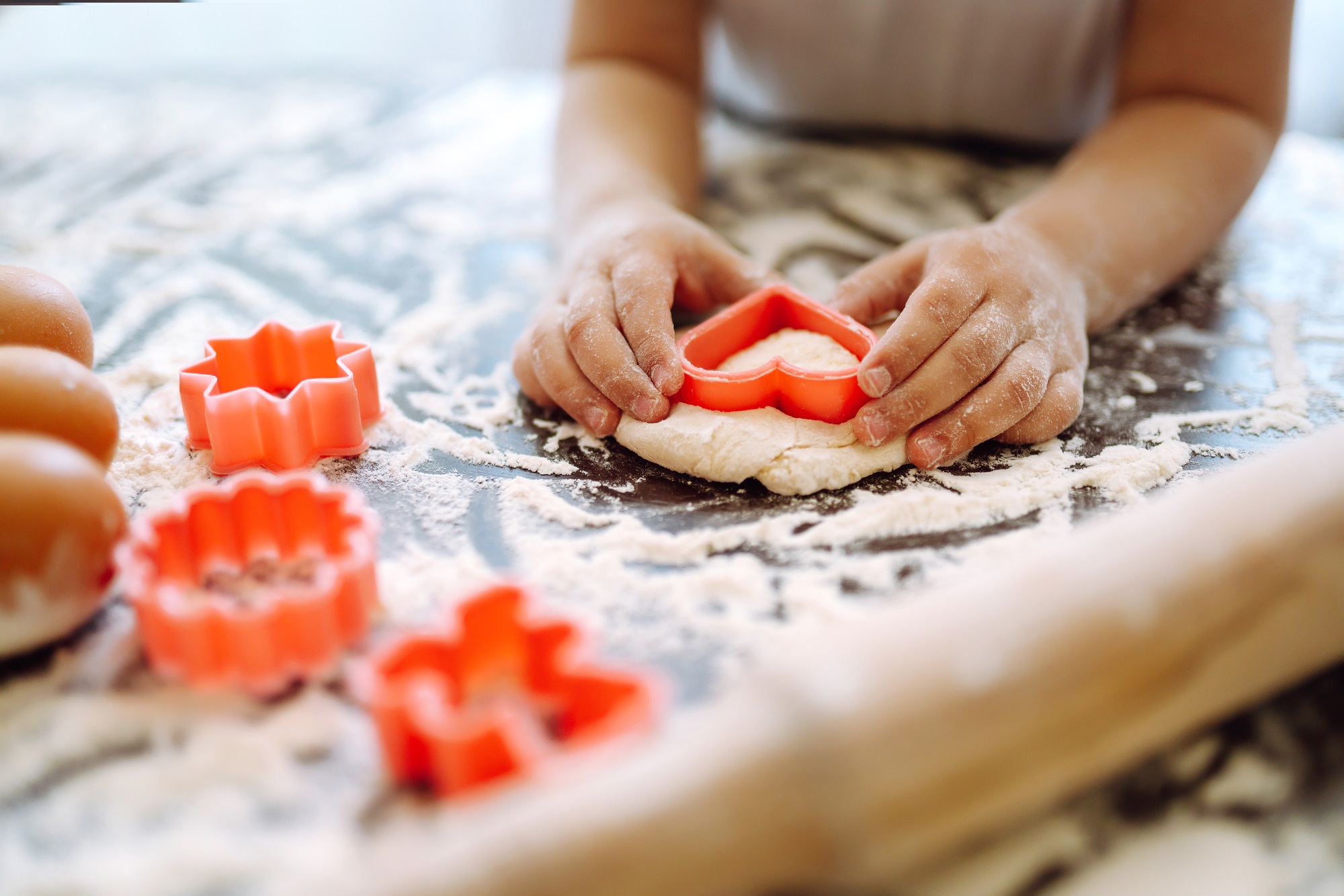 Kids hands cutting out shapes and making cookies. Children's art project, a craft for children.