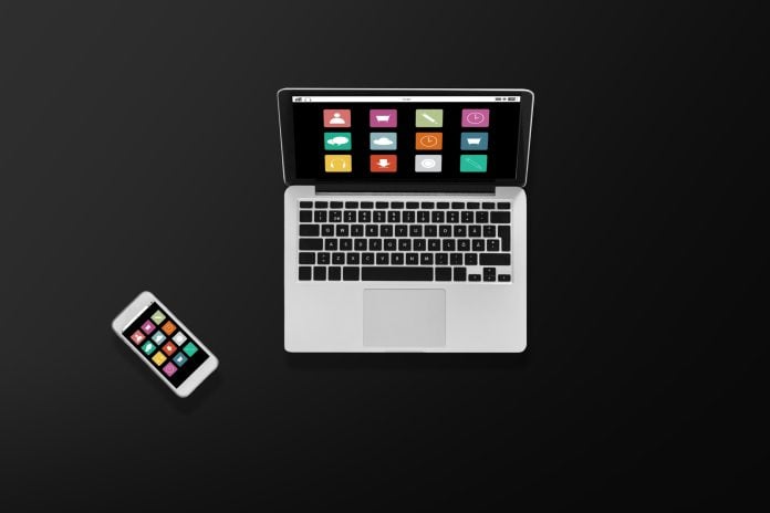 laptop computer with menu icons and smartphone
