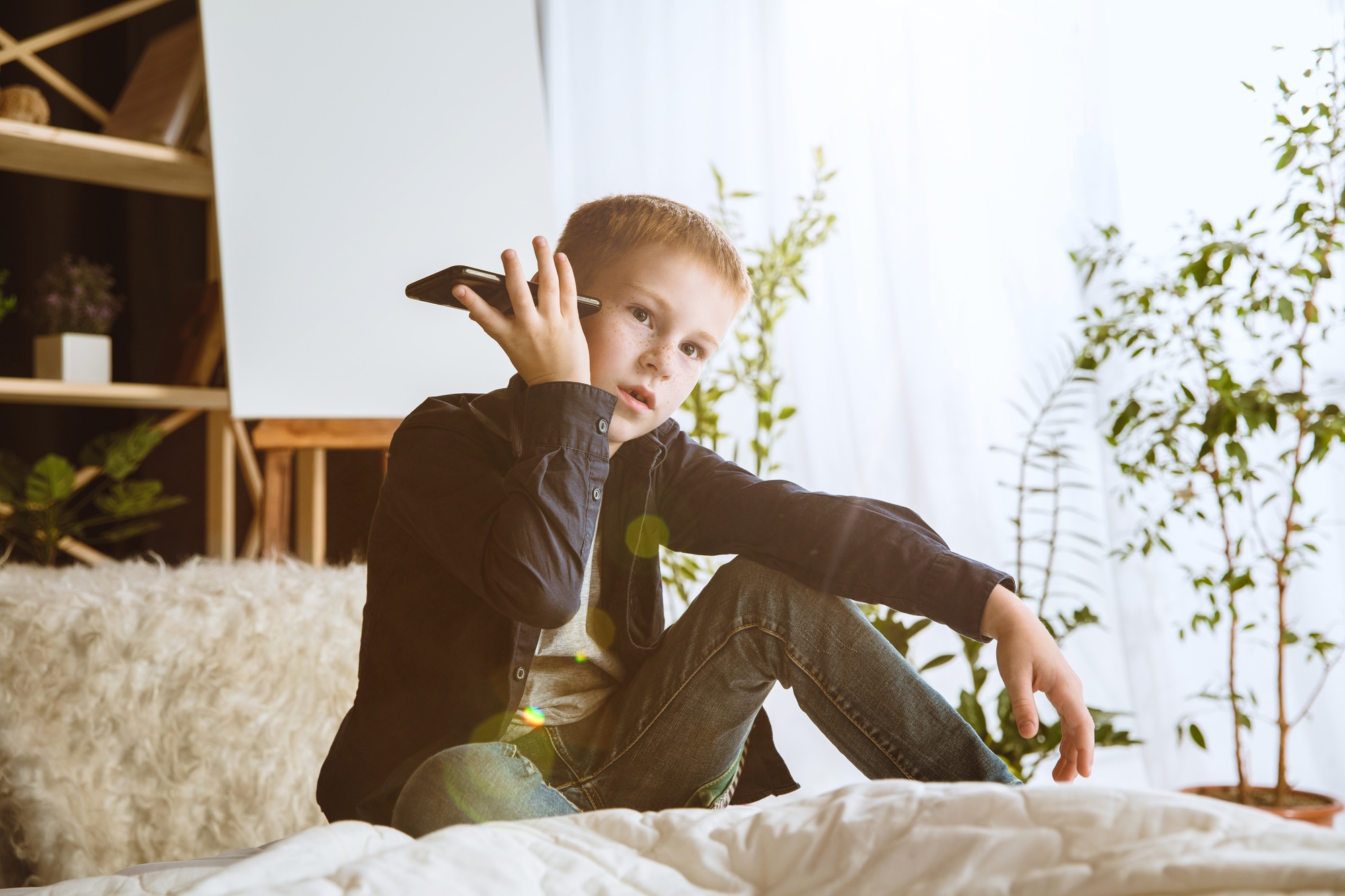 Little boy using different gadgets at home