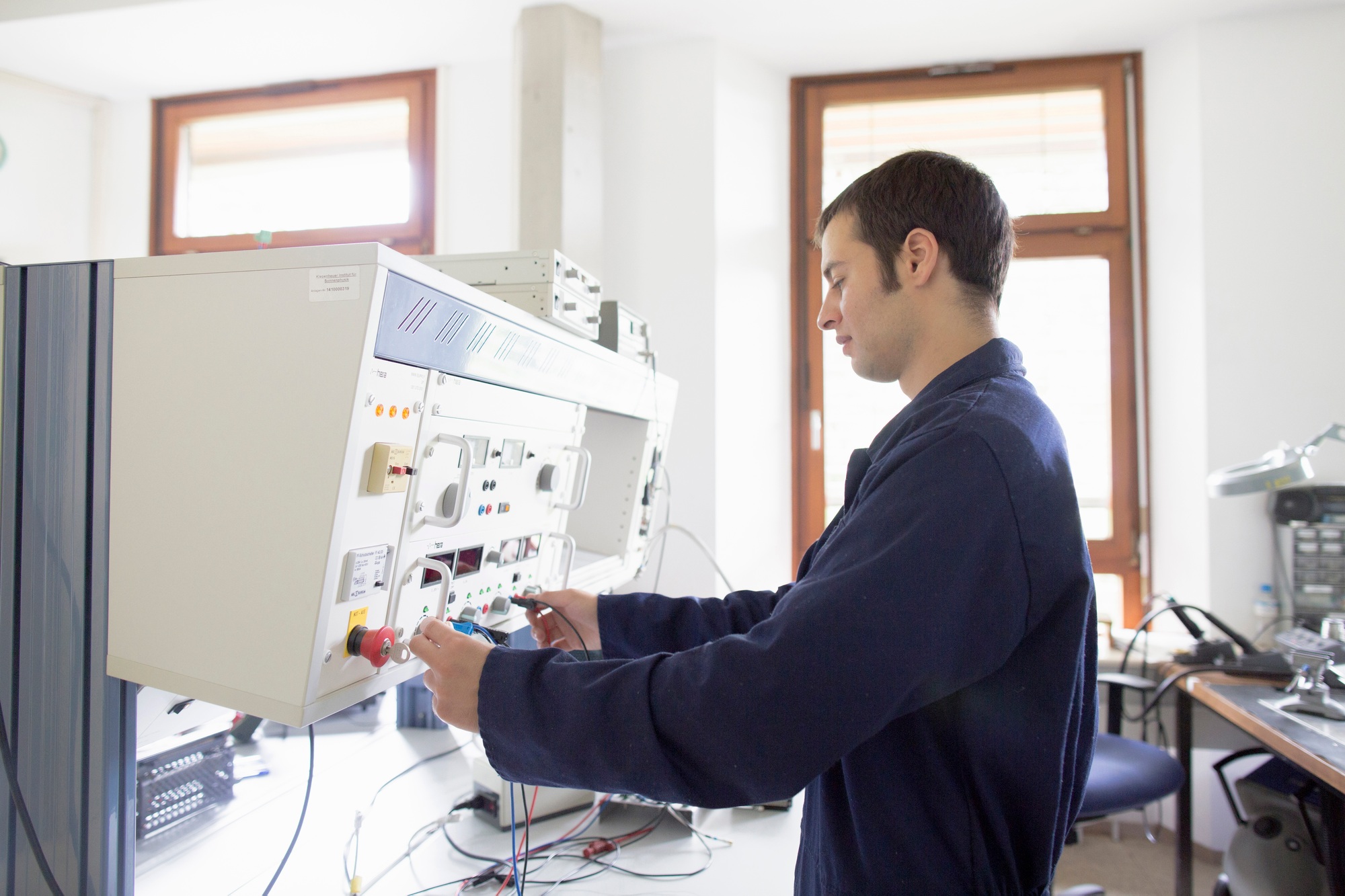 Male electrician testing control panel workshop