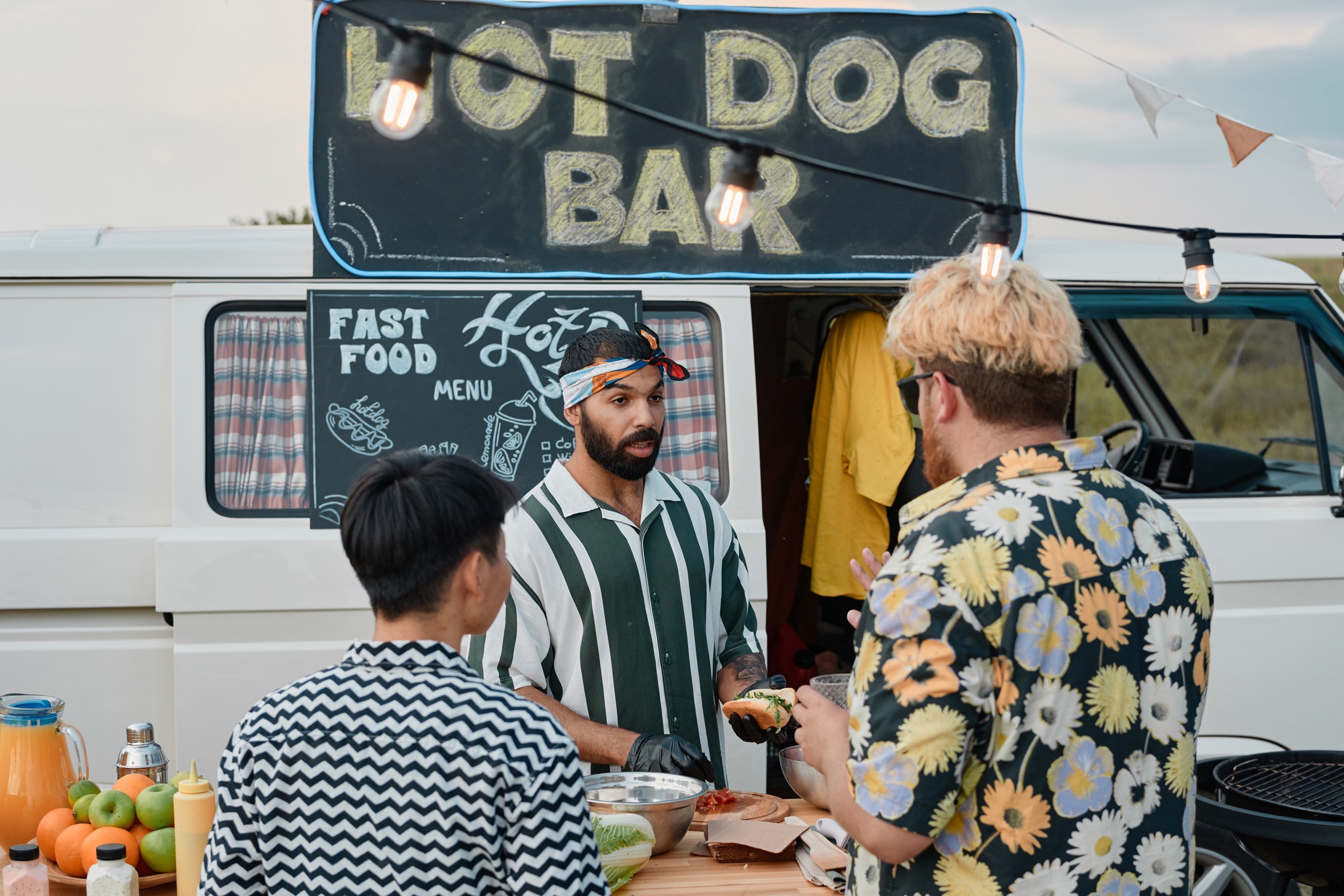 Man cooking hot dogs for people