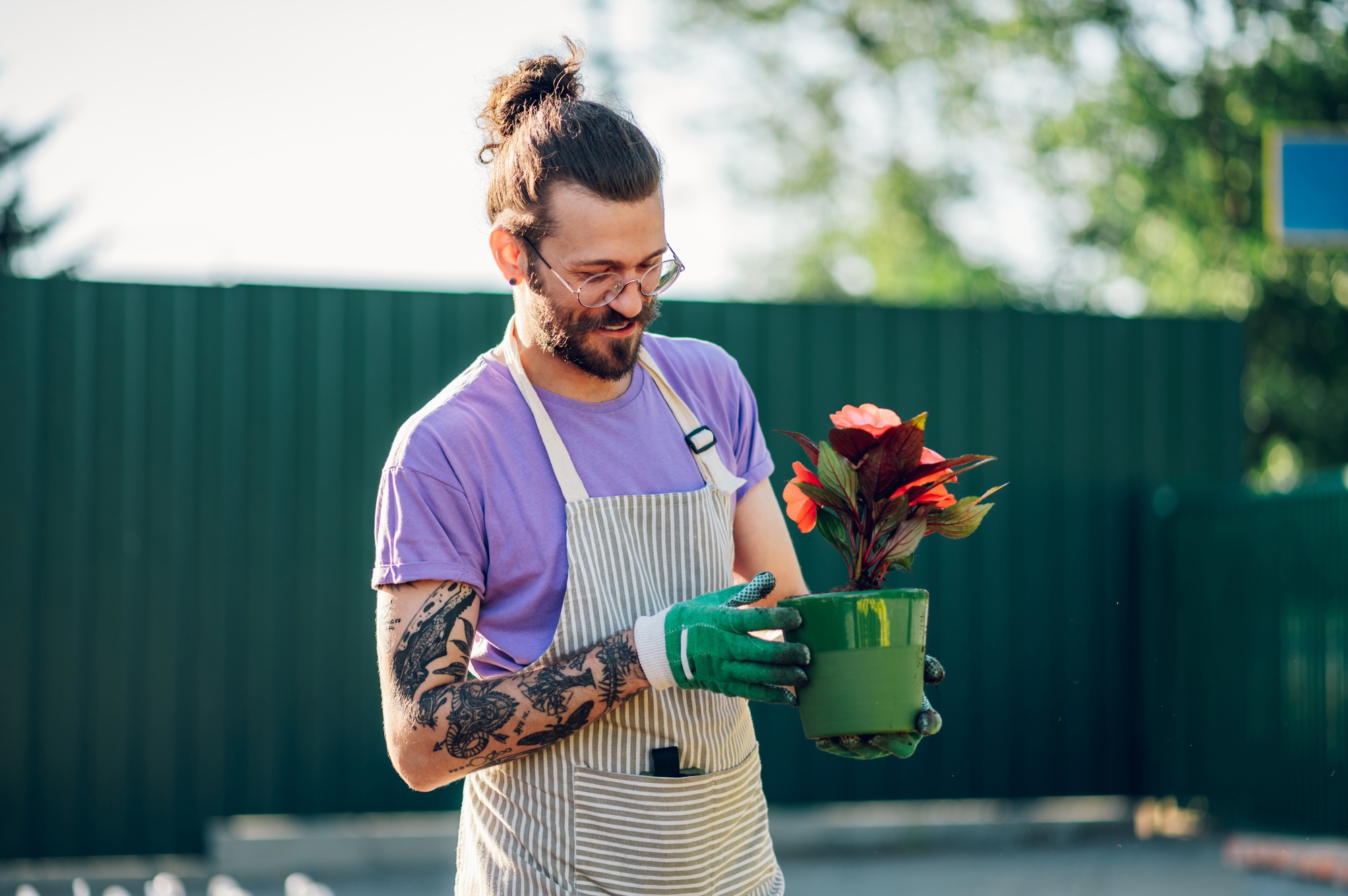 Man transplanting flower pot plants at the table in a plant nursery